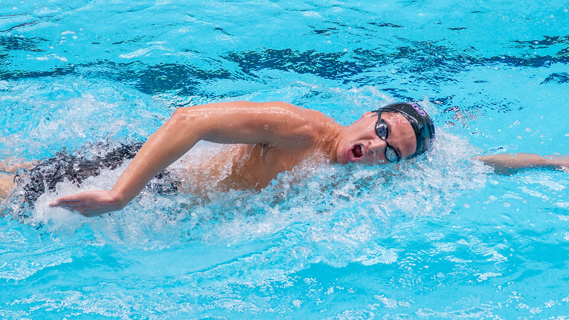 Adam Mekrami swims in competition