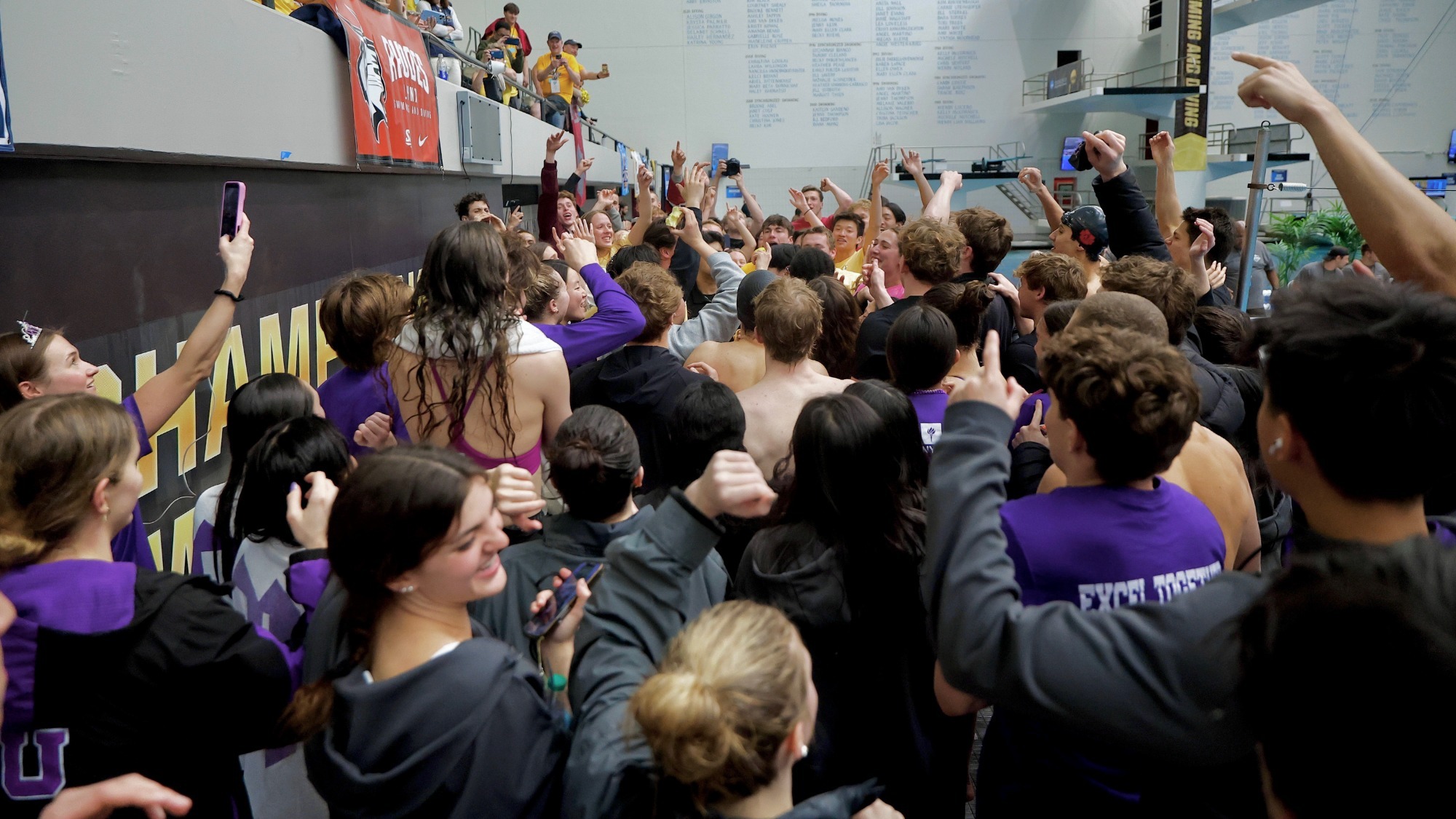 NYU men's and women's swim teams cheering together at 2026 NCAA Championships