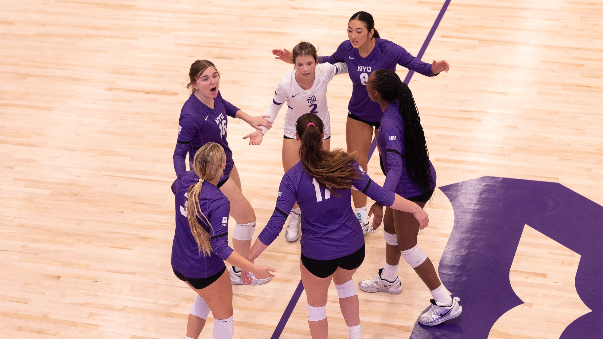 Women's volleyball huddles on the court against Montclair State