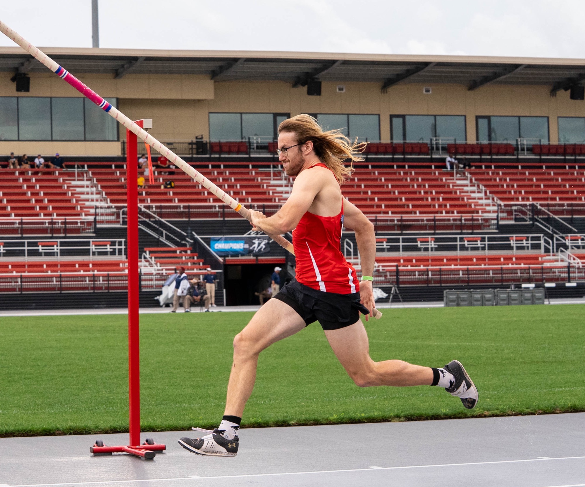 Sullivan Gleason runs down the runway to pole vault over the bar