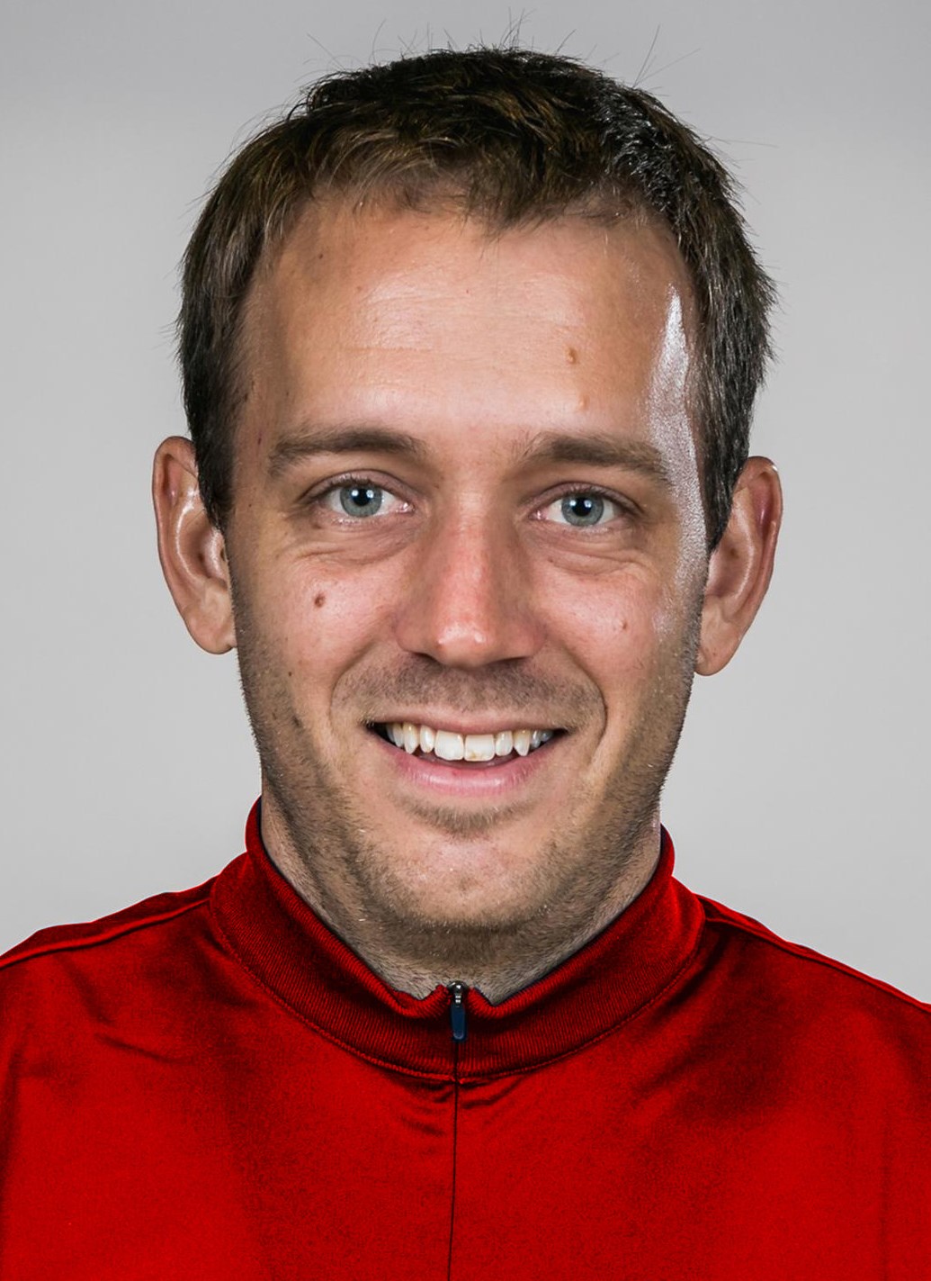 Ben Mallue headshot with red jacket