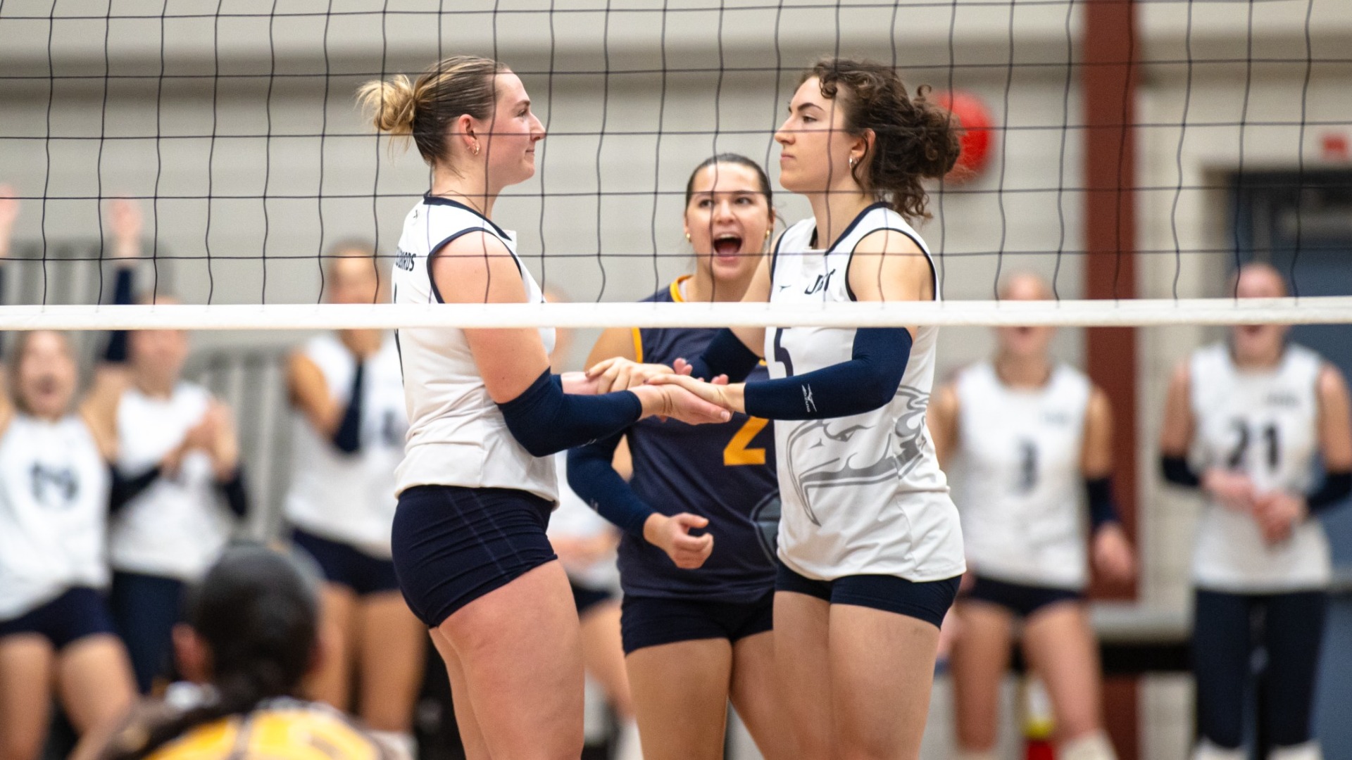 Issy Robertshaw and Aimee Skinner high-five with serious looks on their faces
