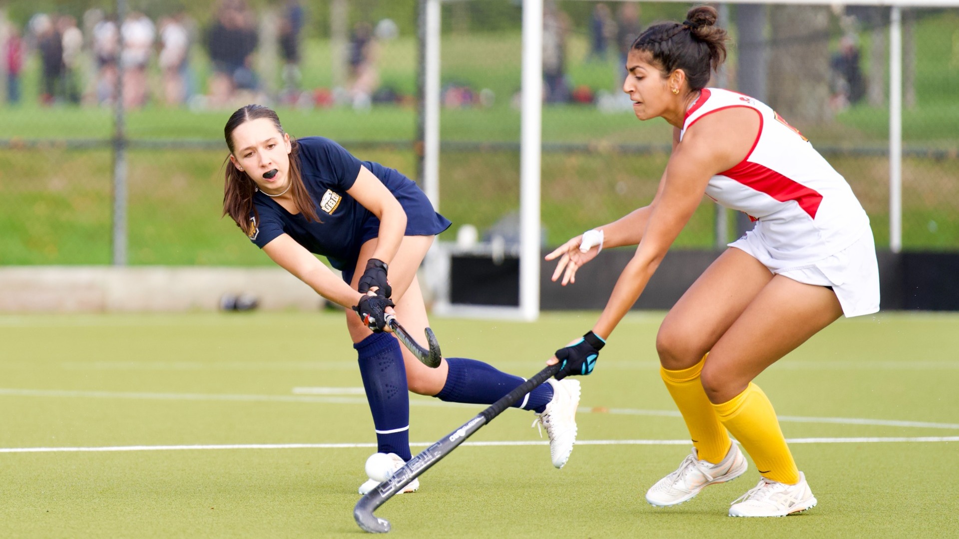 Maia Lawrence tries to fire the ball over the stick of a Calgary defender