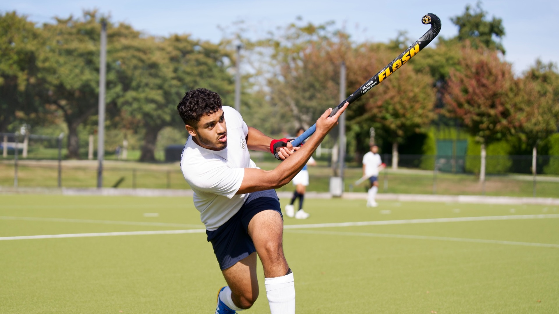 A UBC player holds a follow-through after hitting the ball low to the ground