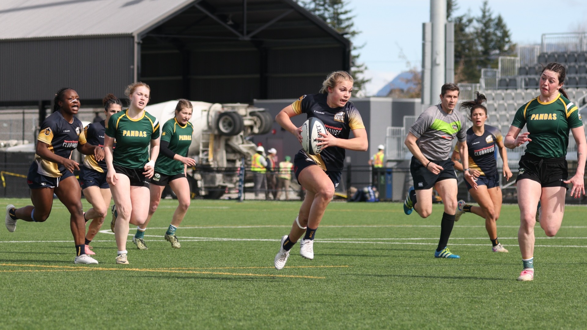 A T-Birds player running diagonally through a pocket of open space with the ball, surrounded by players from both teams 