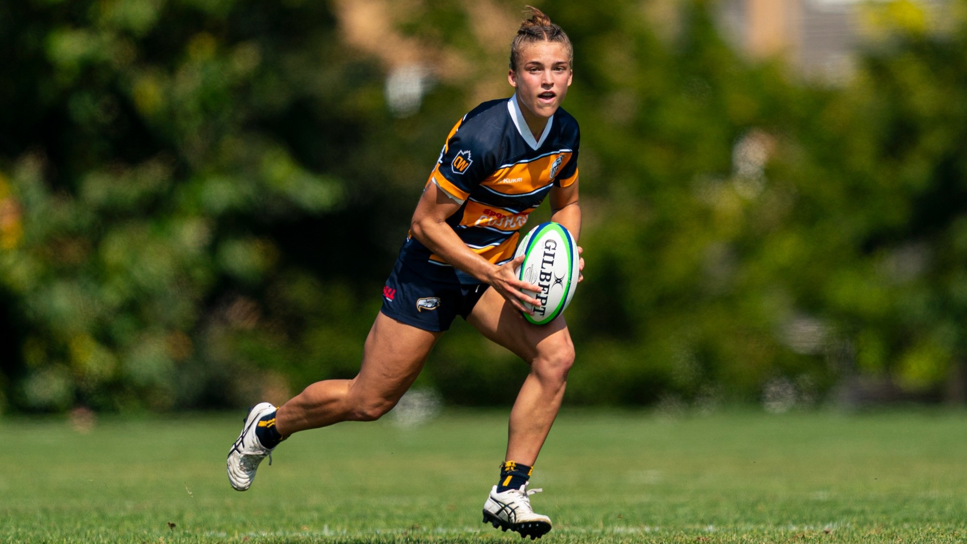 A UBC player runs with the ball in her hands while looking up