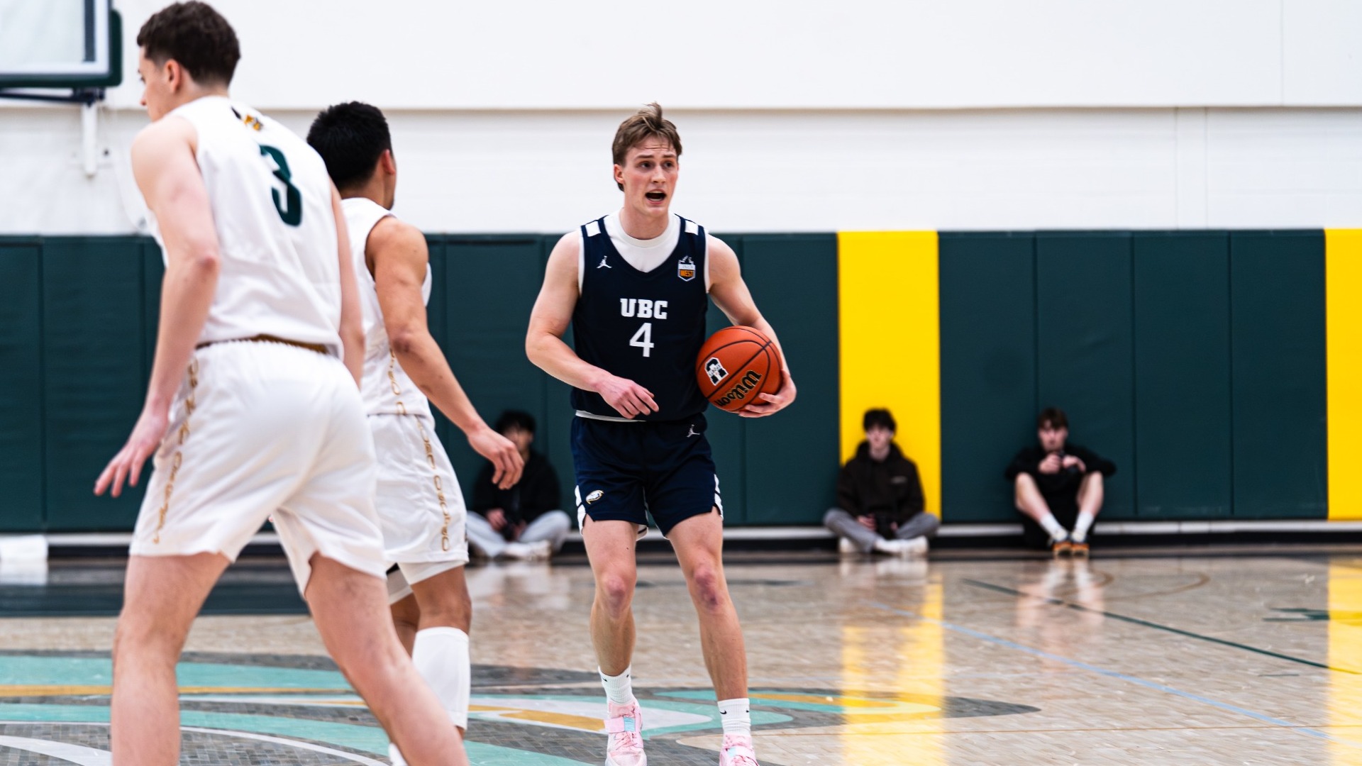 Holt Tomie holds the ball near halfcourt while yelling out something