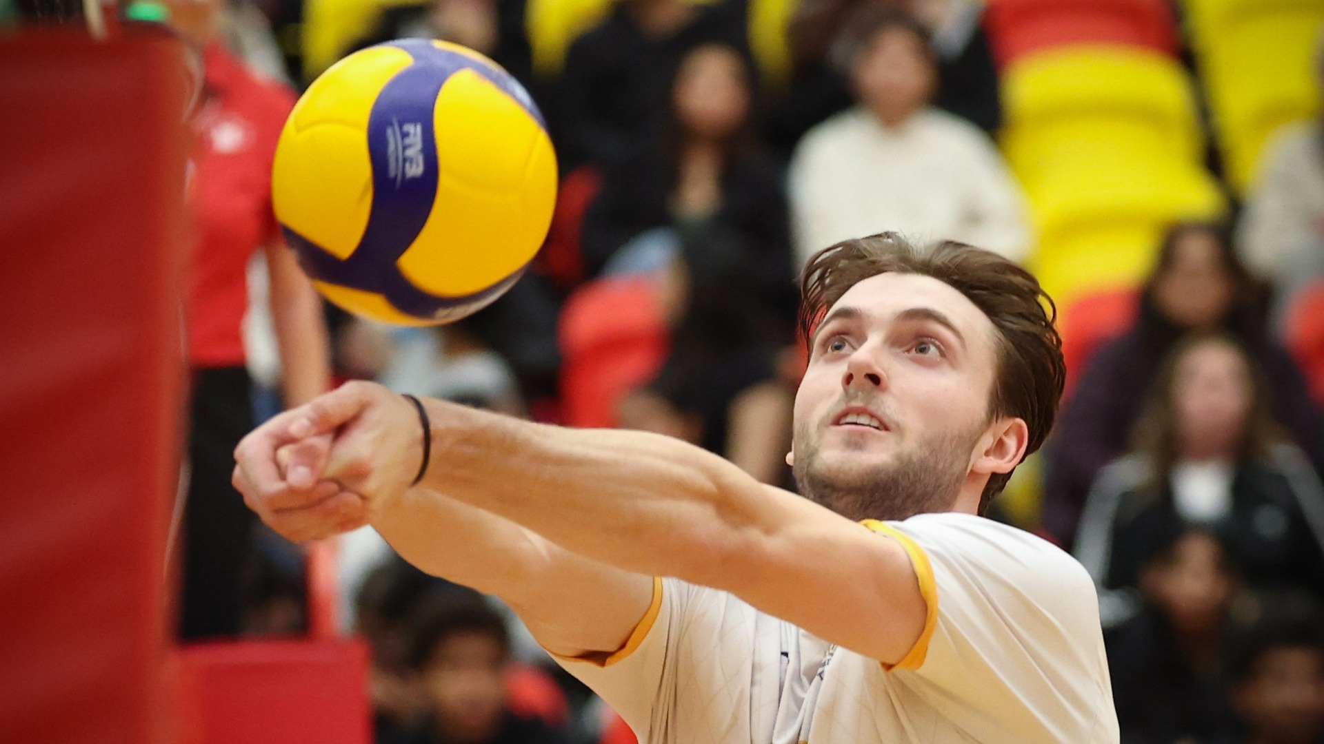 UBC Thunderbirds setter Mason Greves seen in semi-closeup making a bump set, his eyes wide as he makes contact with the ball
