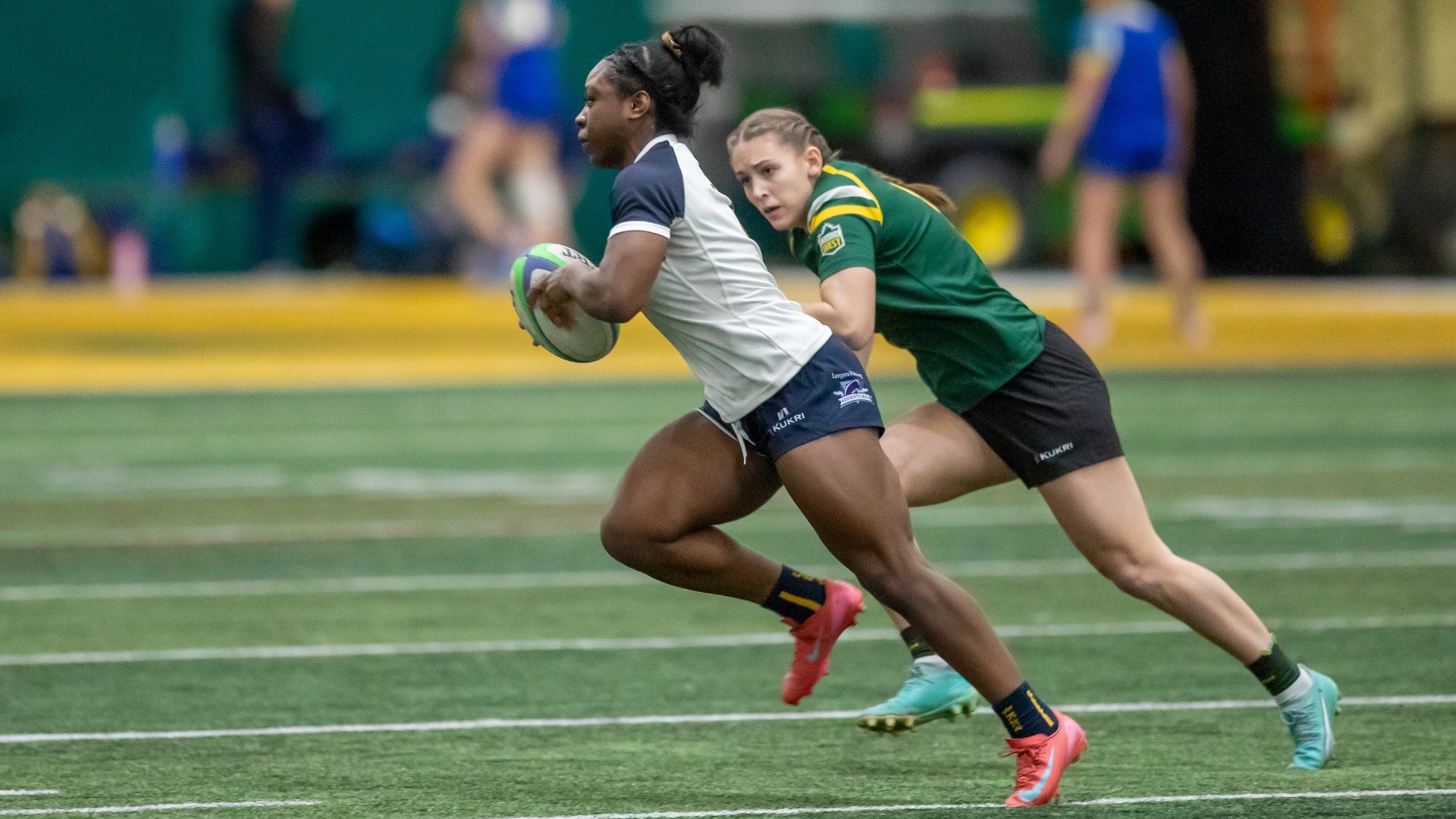 Kiki Idowu runs with the ball while pursued by a defender
