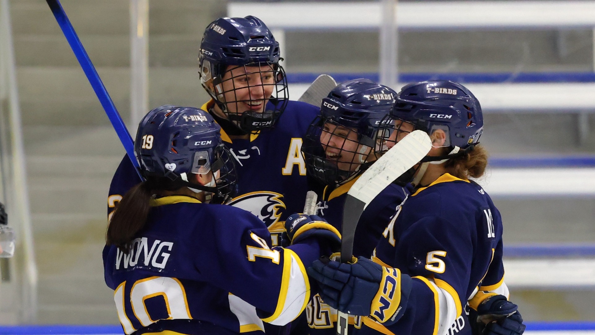 Four UBC women's hockey players celebrate a goal