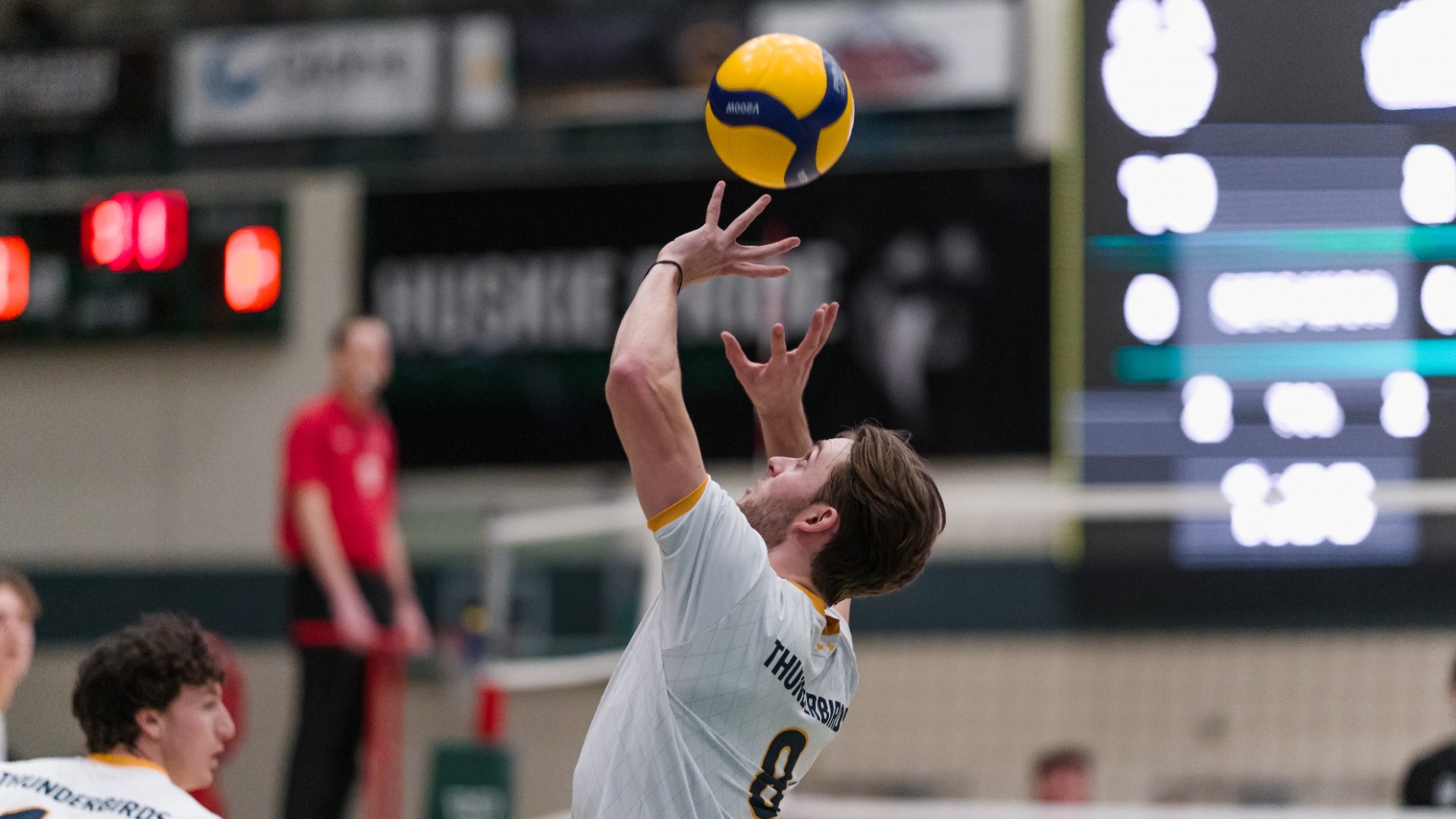 UBC Thunderbirds setter Mason Greves seen from the side in semi-closeup setting a ball