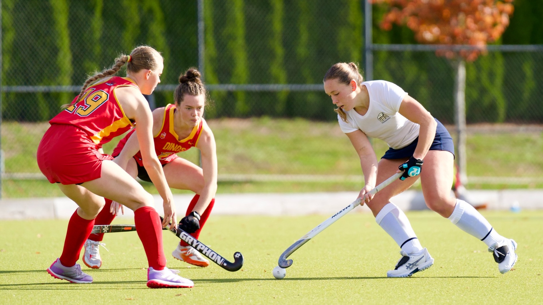 A T-Bird handles the ball with two defenders closing in during a game against the Calgary Dinos on Oct. 18, 2026