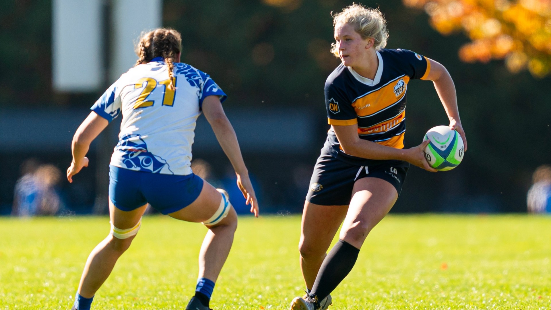 A UBC player runs with the ball towards a defender