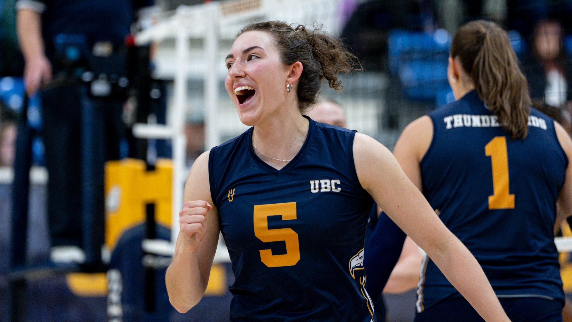 UBC Thunderbirds setter Issy Robertshaw smiling and yelling in celebration after her team won a point