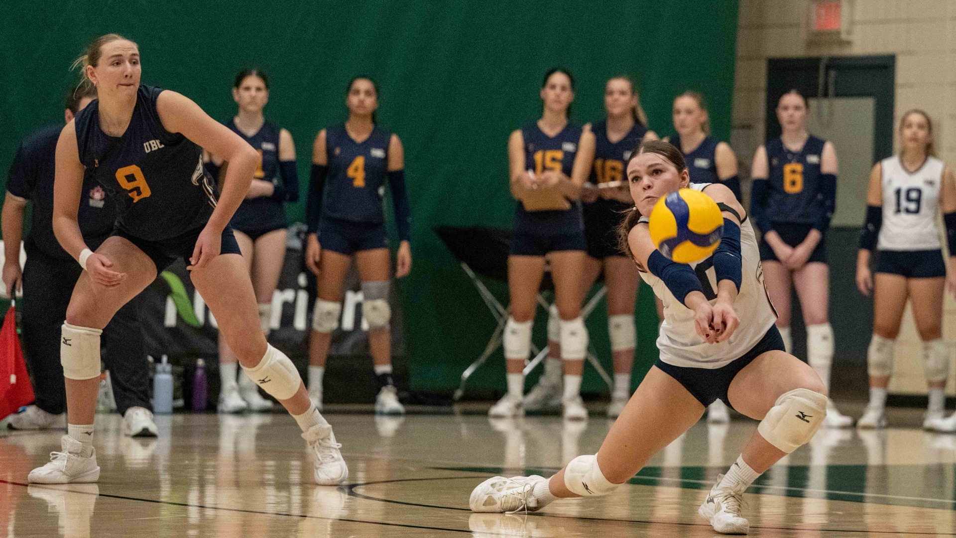 Gabrielle Flaman stoops down to dig the ball