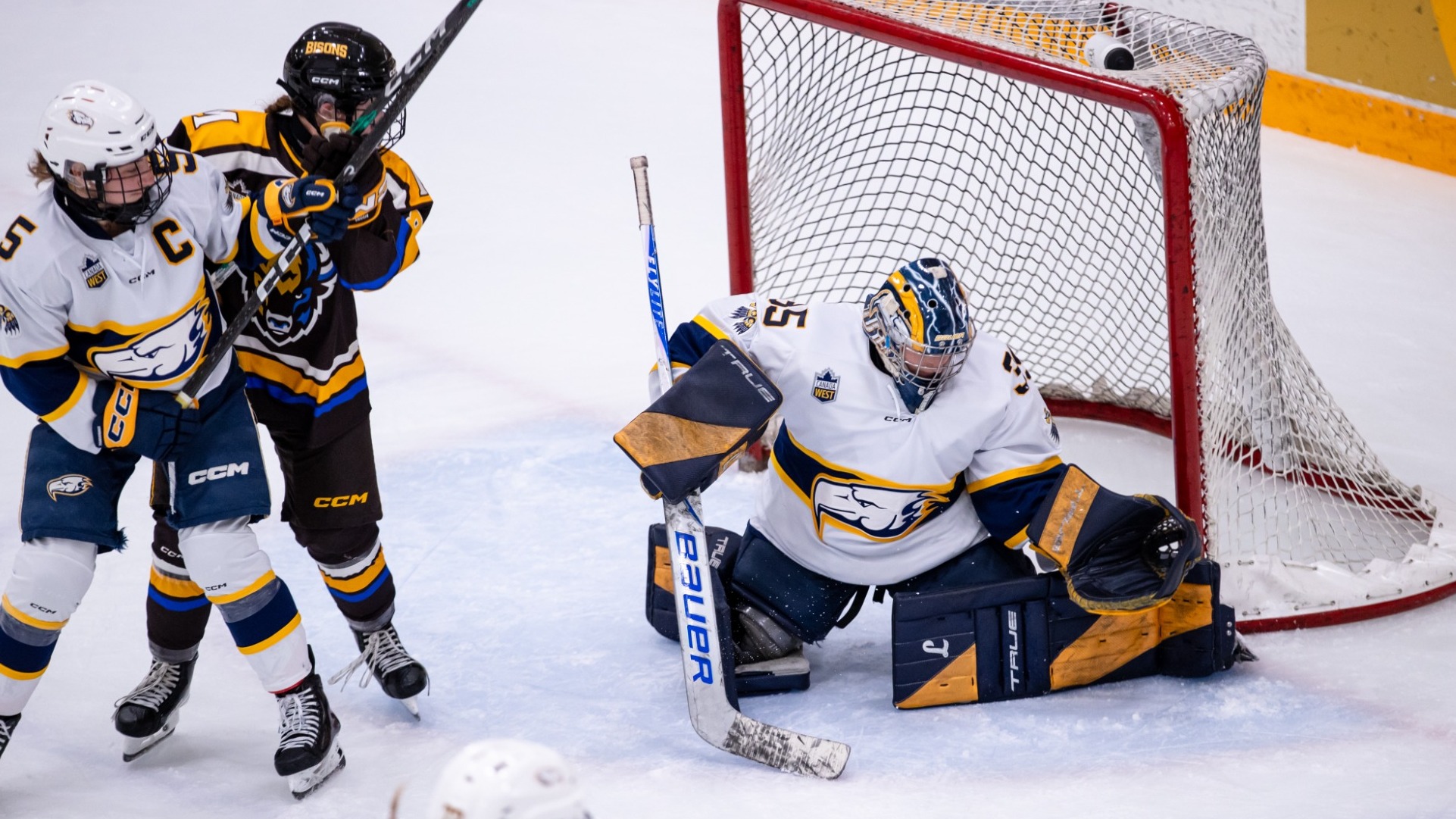 UBC netminder Adriana Almeida makes a save with a T-Bird and a Bison battling in front of the crease during a game against the University of Manitoba Bisons on Oct. 9, 2026
