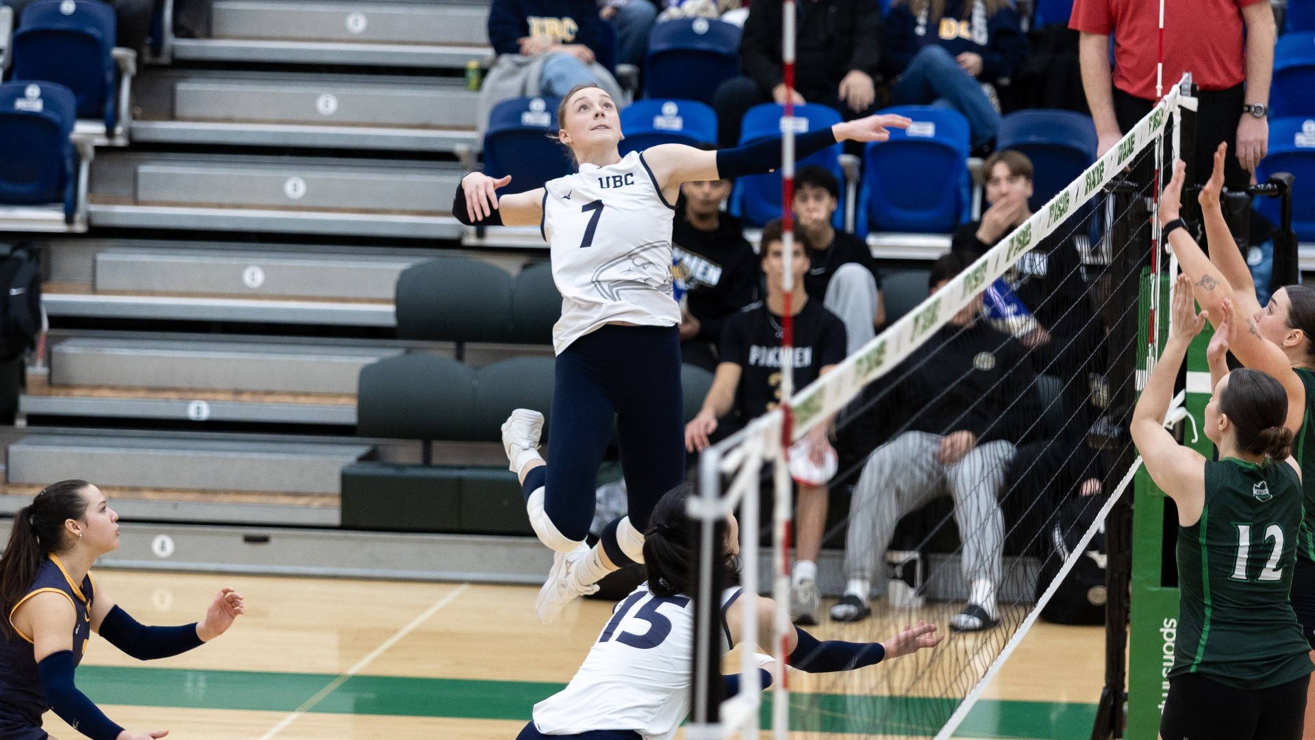 UBC Thunderbirds outside hitter Elizabeth Lee jumping high in the air, her arm cocked, about to swing at a set, a look of intense anticipation on her face
