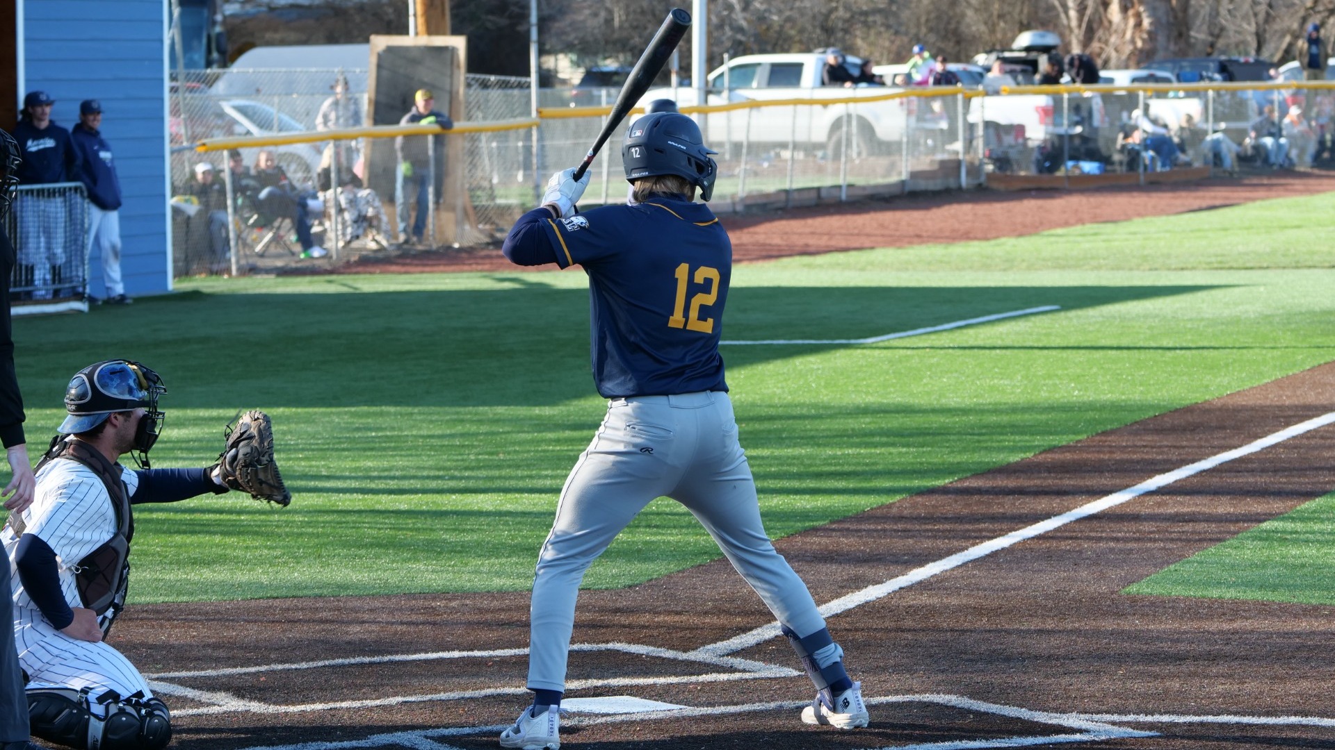Kellen Bourne stands in the batter's box with his back to the camera, awaiting a pitch