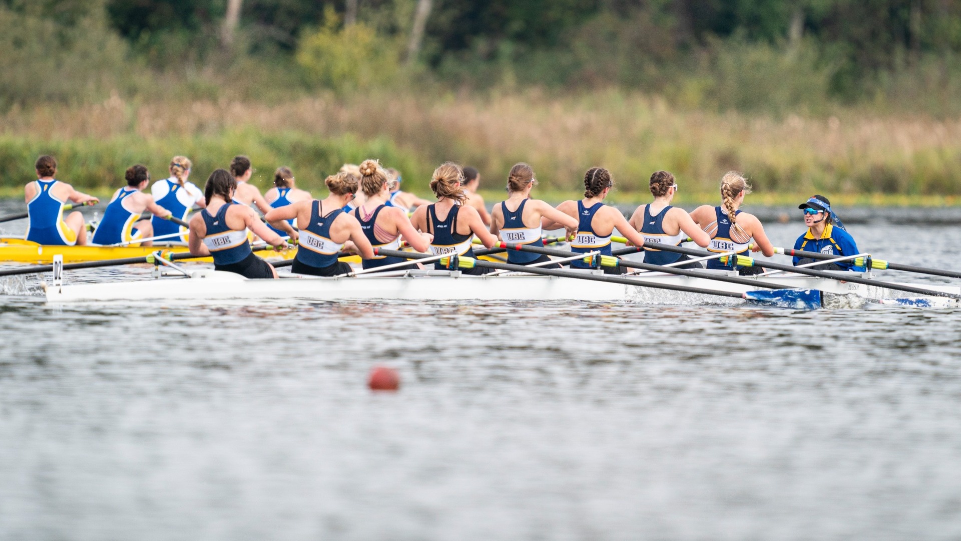 UBC women's rowers race across the water in a boat of eight people