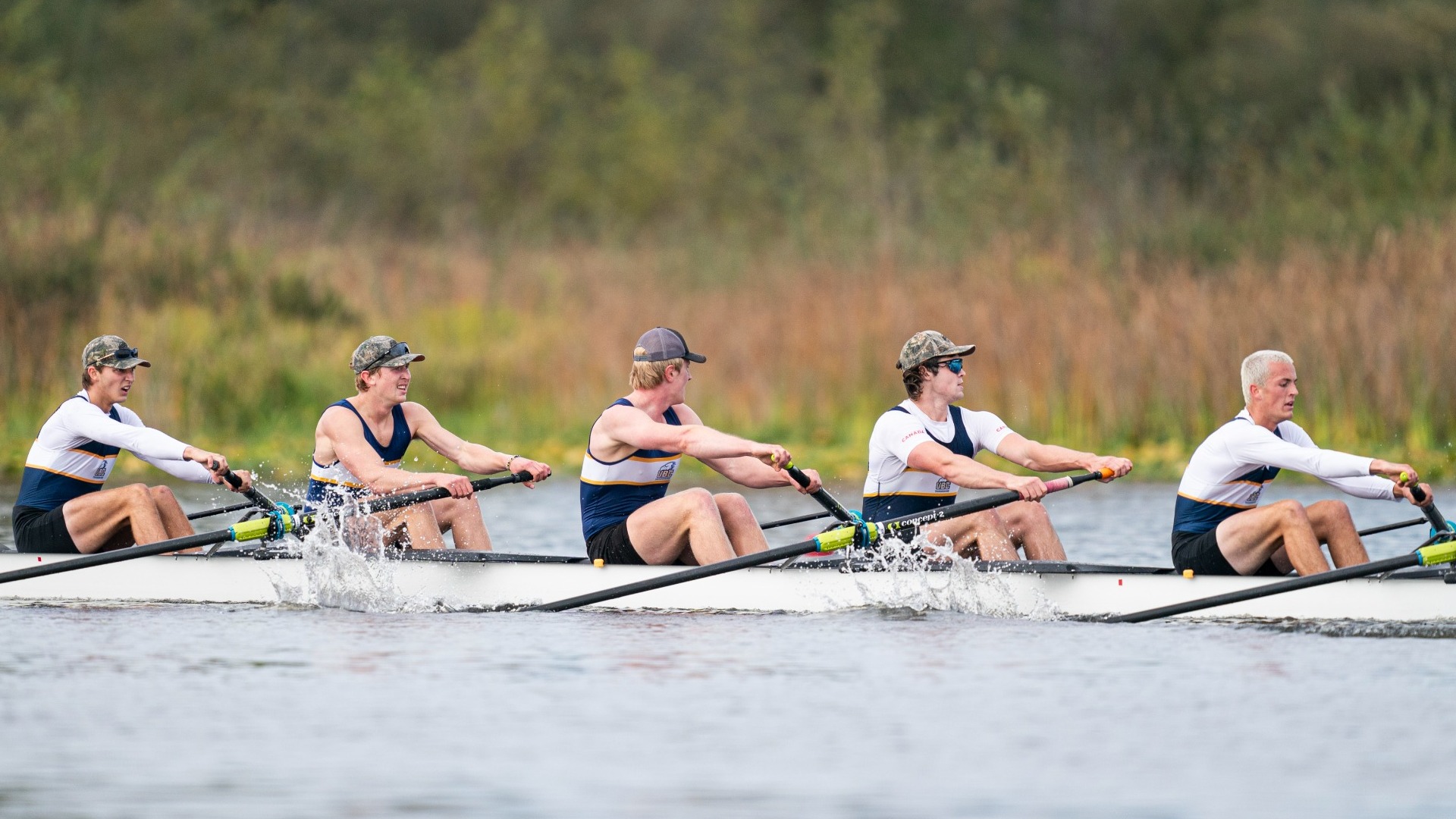 A group of UBC men's rowers race through the water