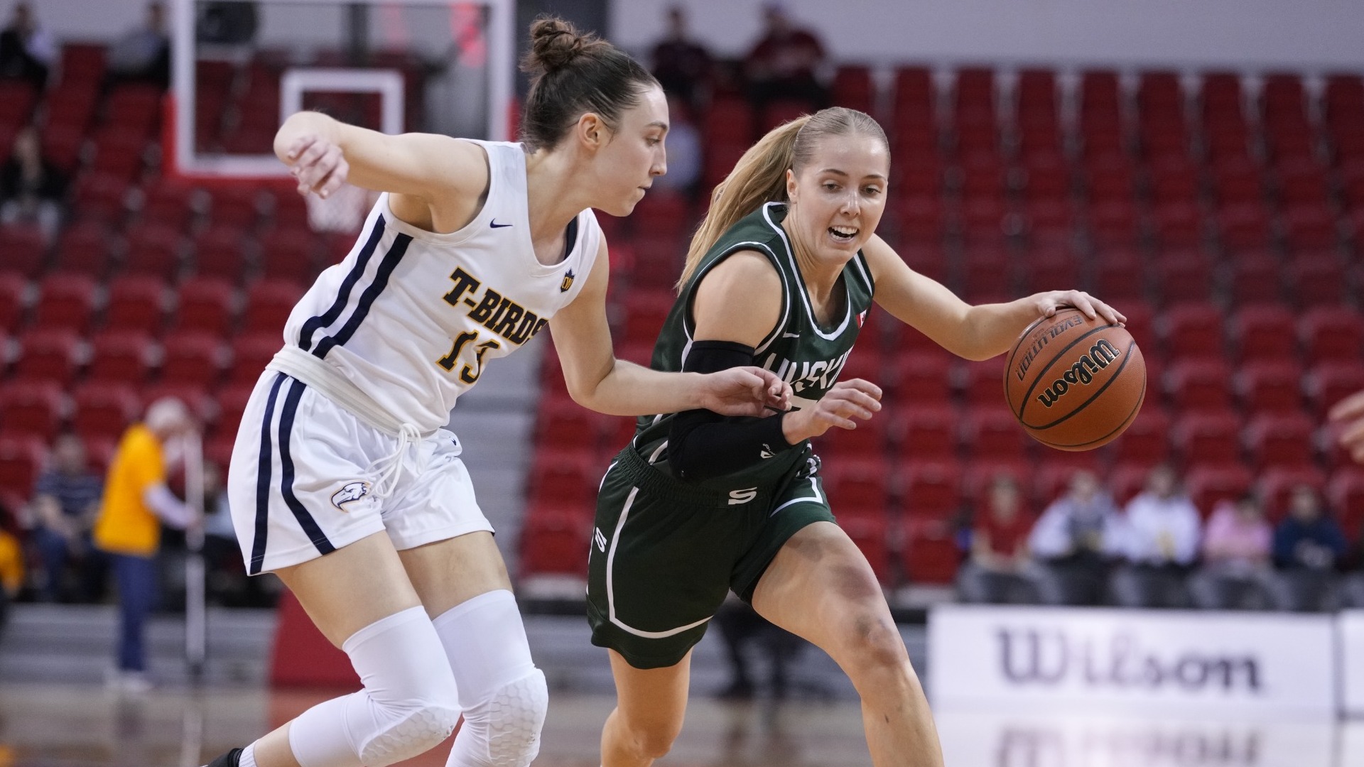 Stella LaGrange keeps up with a Huskies player who's trying to dribble the ball past her