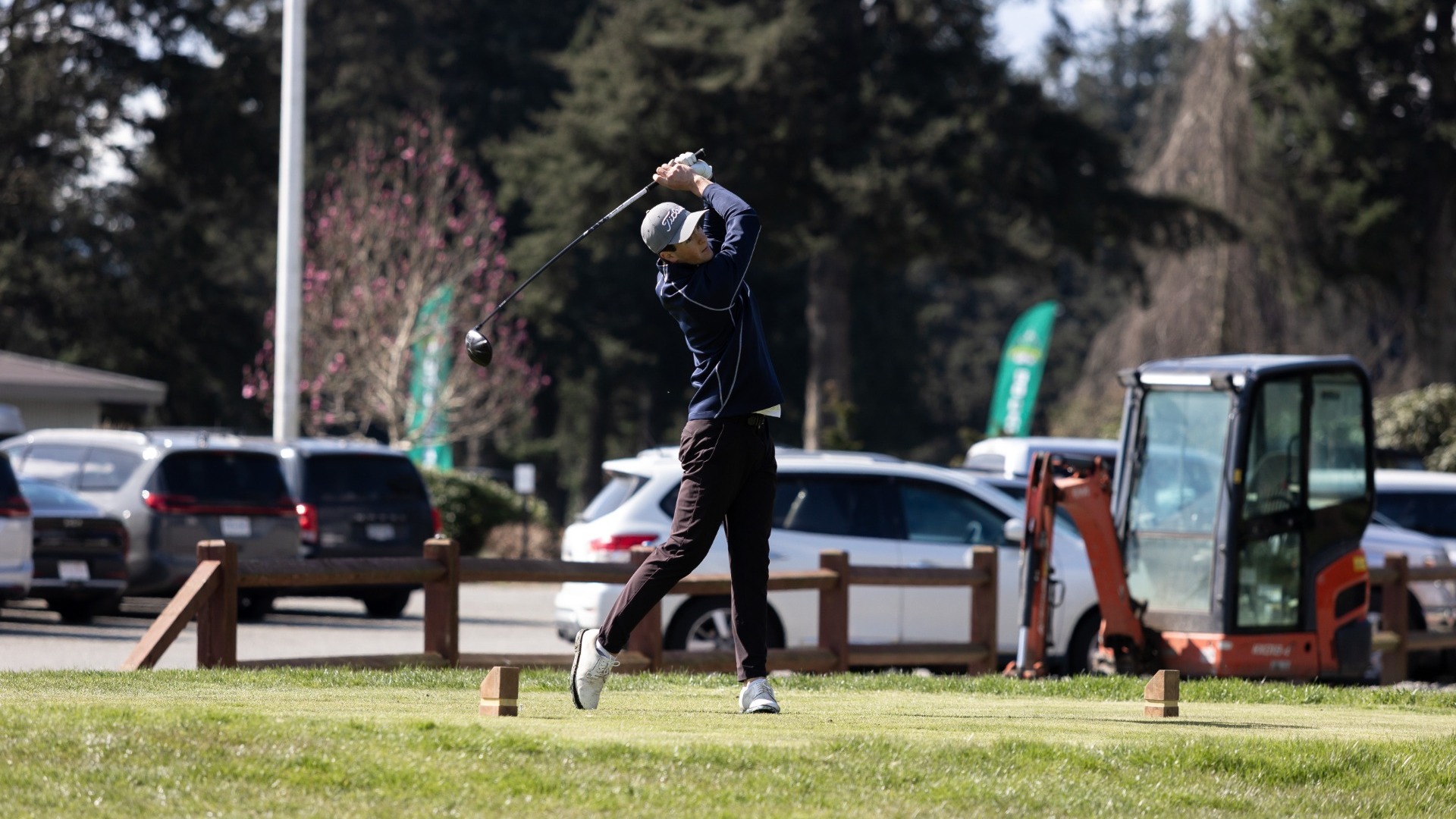 A UBC men's golfer holds a follow-through after hitting a tee shot