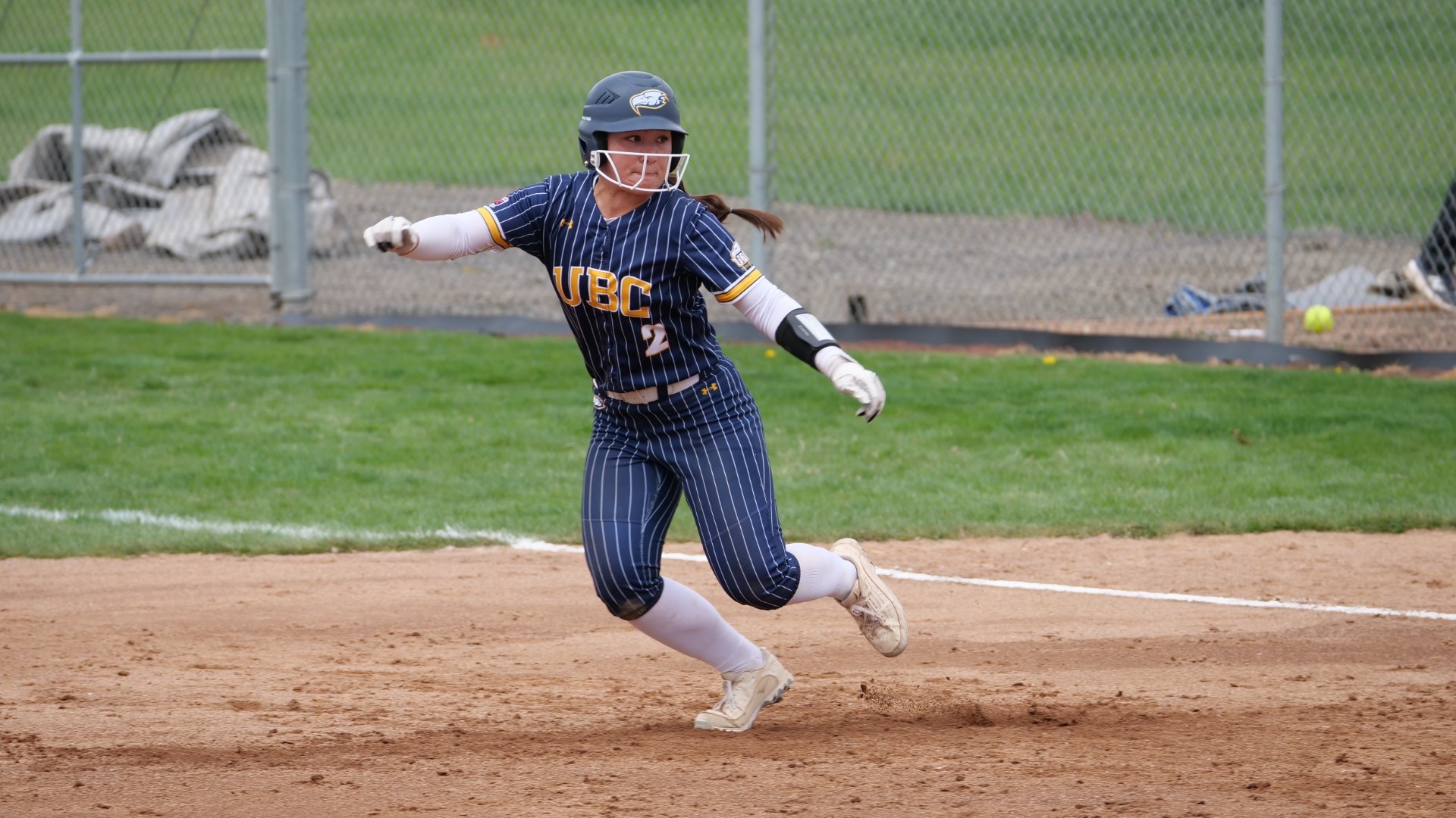 Jillian Matsubara leading off from first base, leaning to her right as she prepares to jump or take an aggressive stride toward second