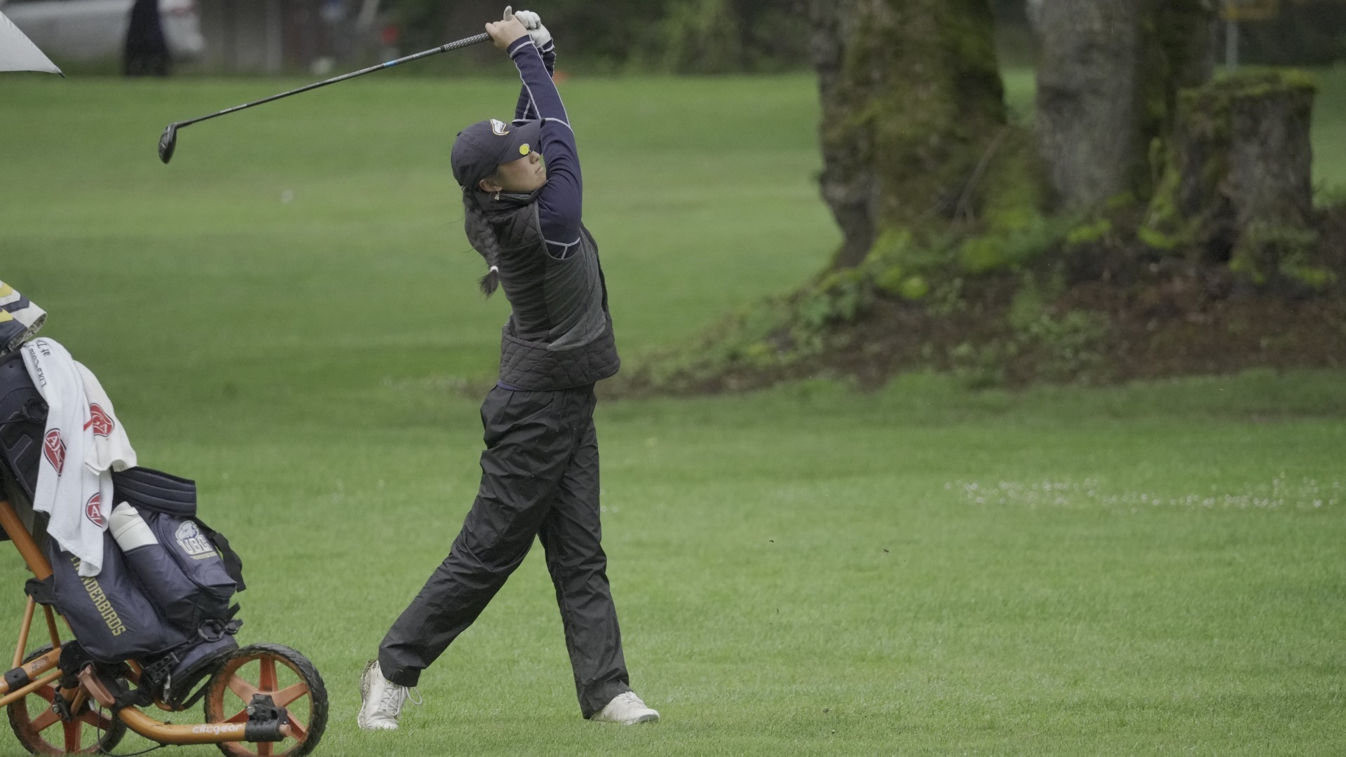 A UBC golfer holds her follow-through after a swing on the fairway