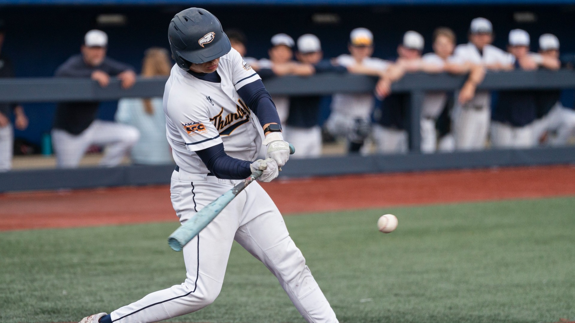 A UBC player swings the bat over the plate to try and hit the ball