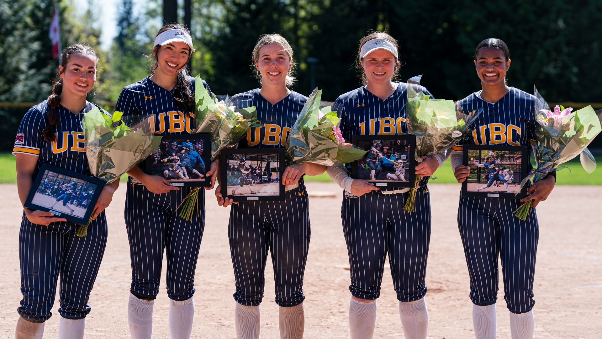 The five graduating T-Birds pose for a picture together with flowers and framed pictures