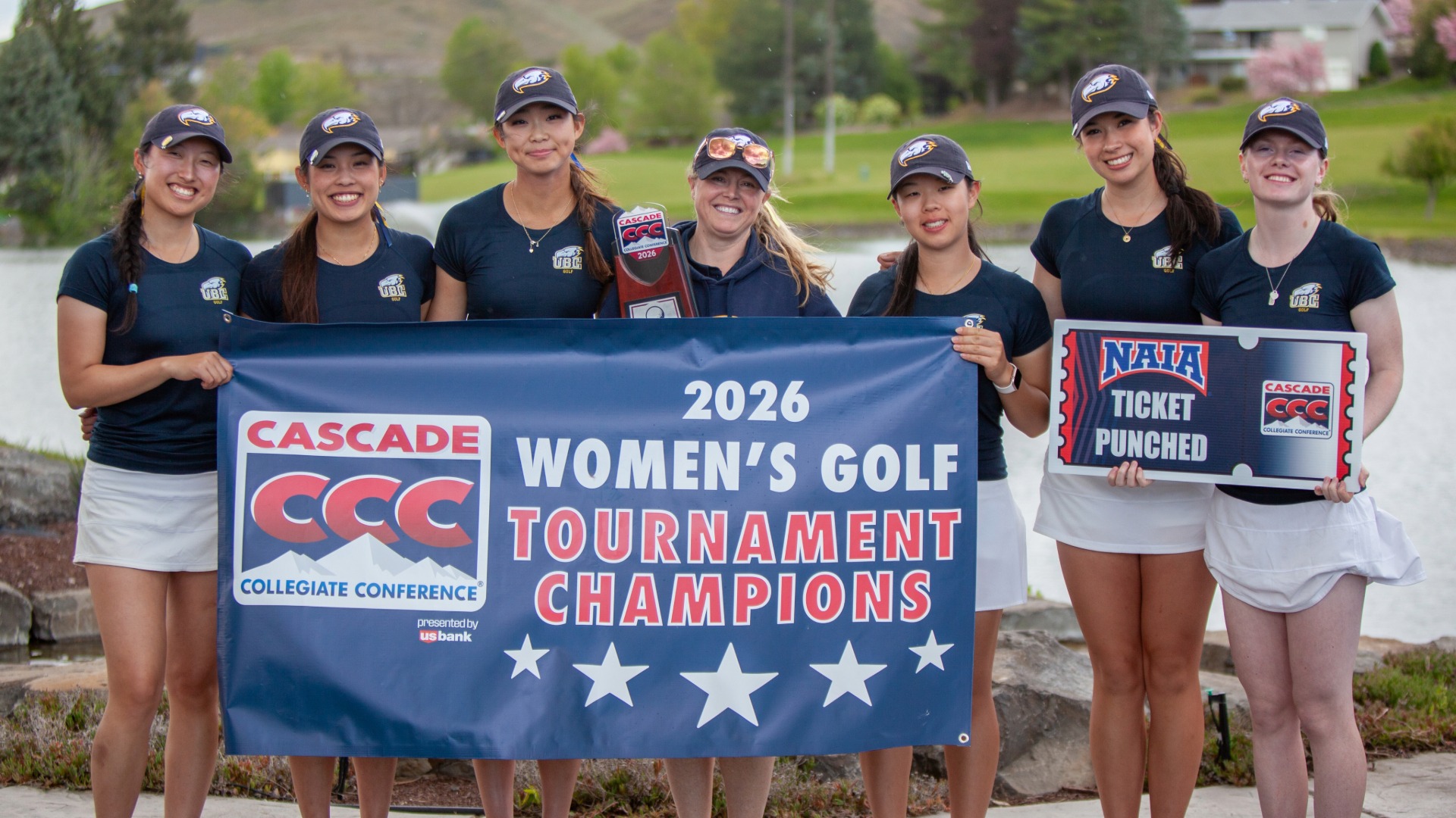 The UBC Thunderbirds women's golf team smiles and poses with the banner declaring them 2026 Cascade Collegiate Conference Champions and an oversized cutout ticket saying 