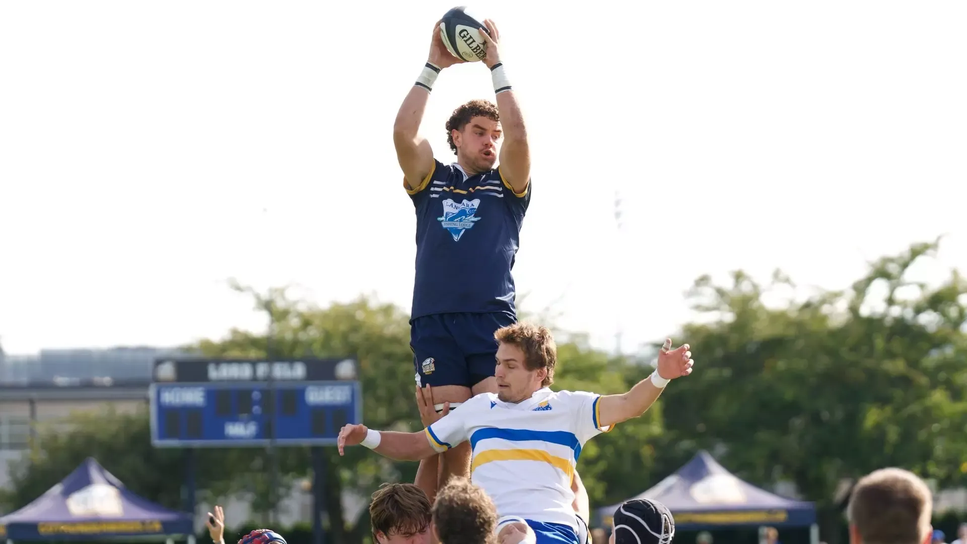 A UBC player reaches up high to grab the ball on a lineout over a Vikes player