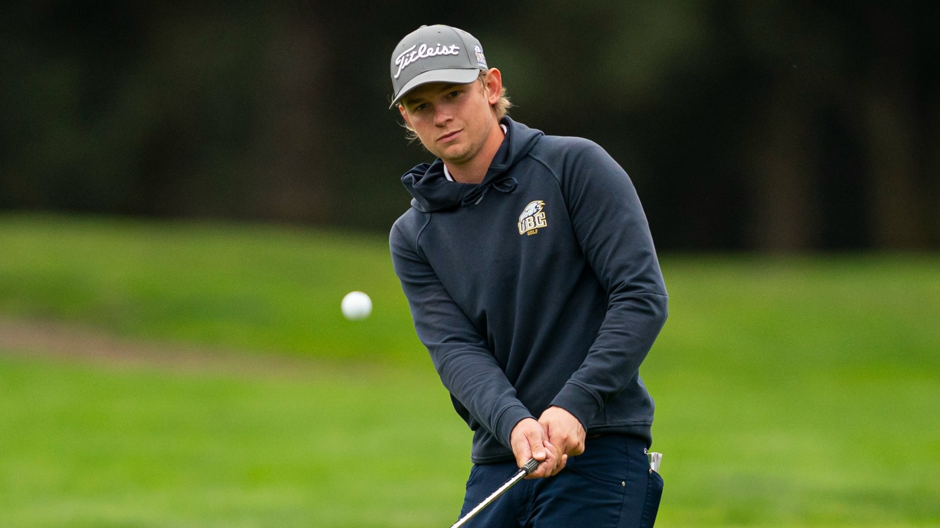UBC Thunderbirds golfer Jake Houson watching the ball he just chipped, the ball in the foregound and out of focus just below his eyeline