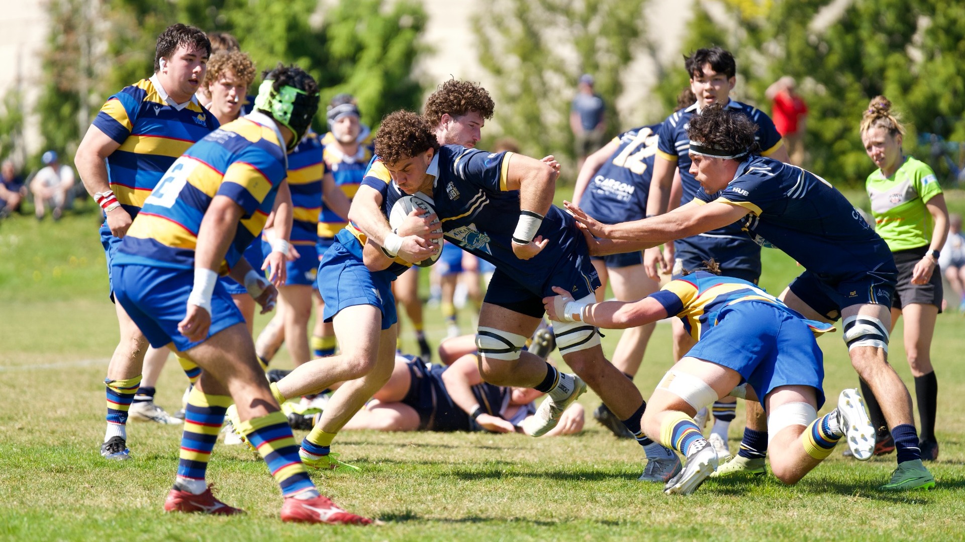 A UBC player tries to run through a mass of players while being grabbed at