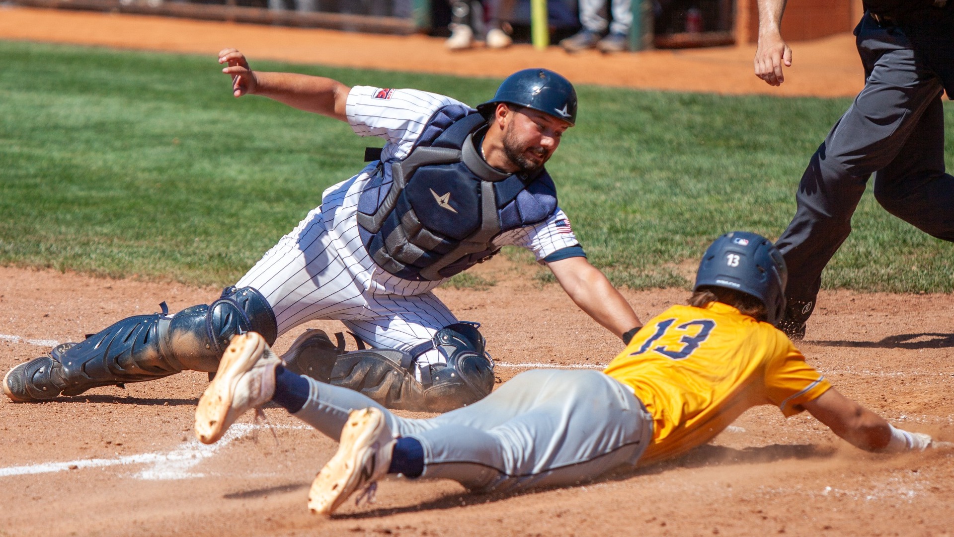 Matt Vanslyke slides into home while the Bushnell catcher attempts to tag him out