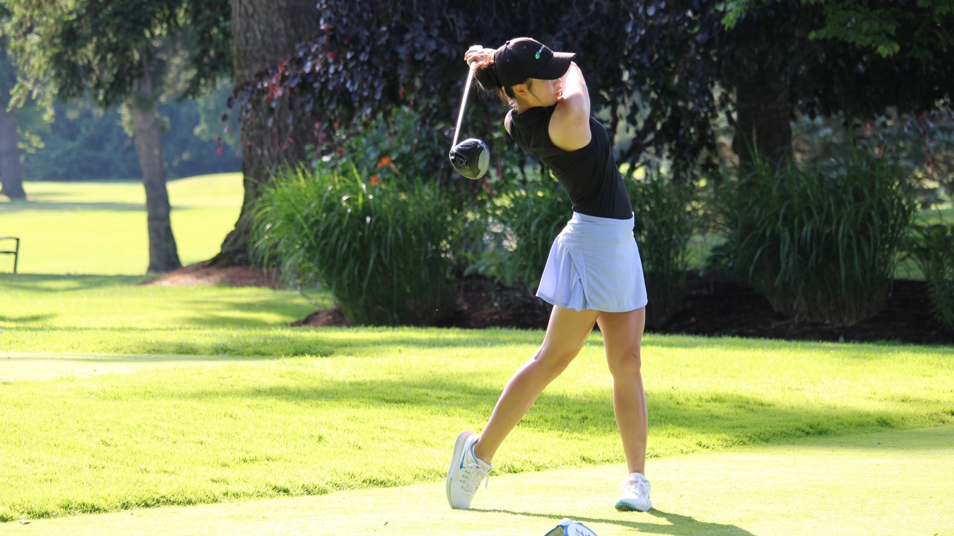 UBC Thunderbirds women's golf recruit Cadence Ko seen from the side as she holds her follow through on the tee box after hitting driver