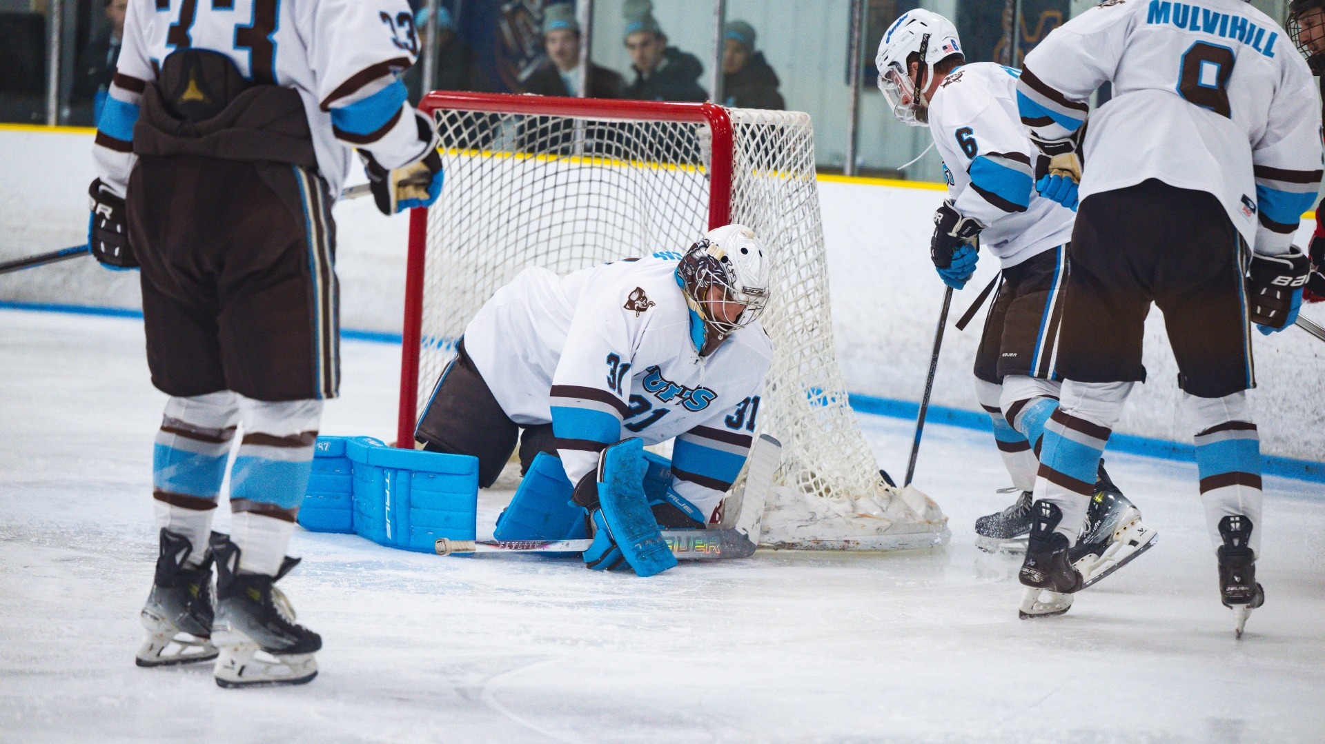 Tufts' Gus Bylin covers up the puck against Wesleyan University.