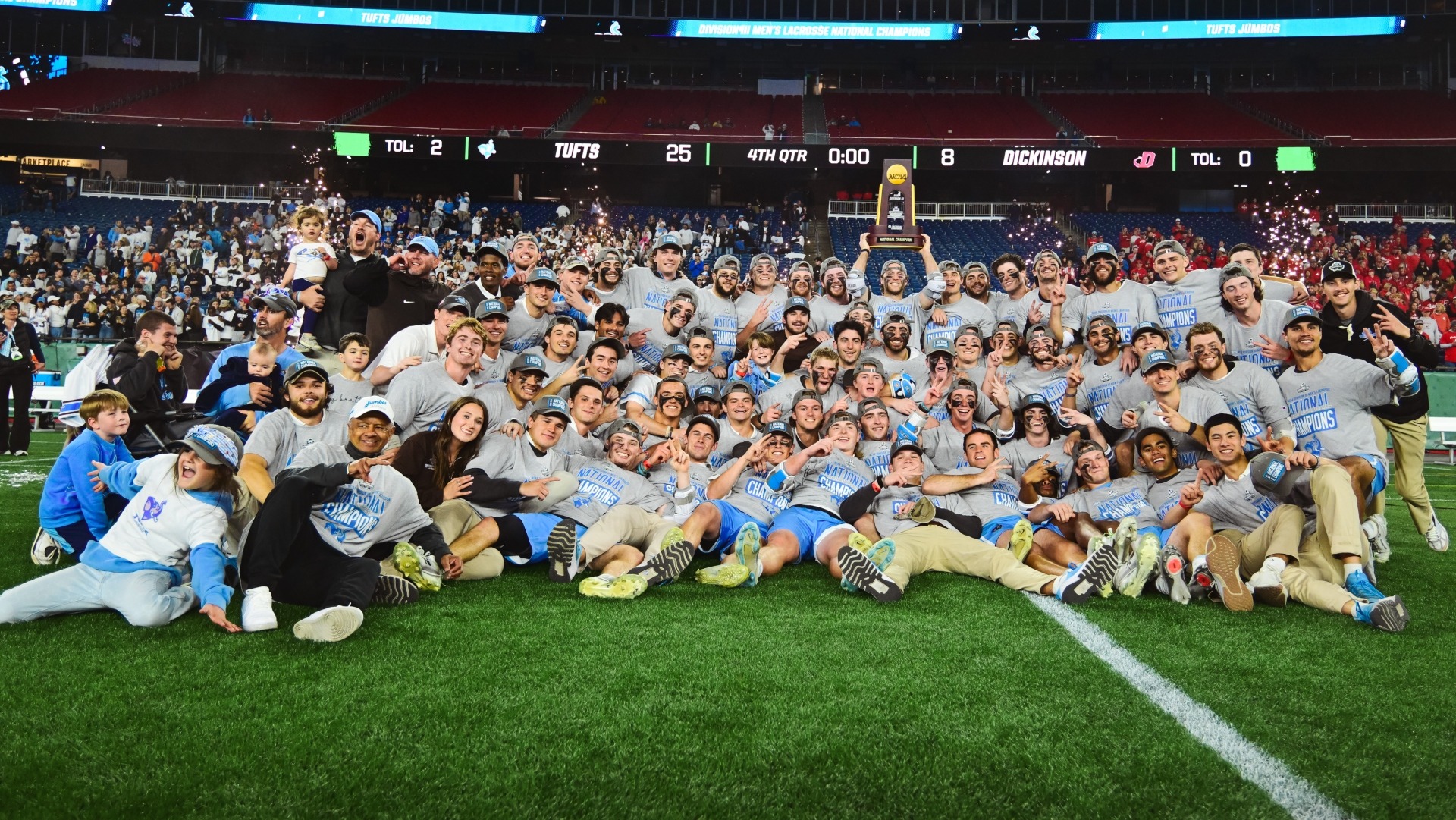 The NCAA champion Tufts men's lacrosse team celebrates with the NCAA trophy.