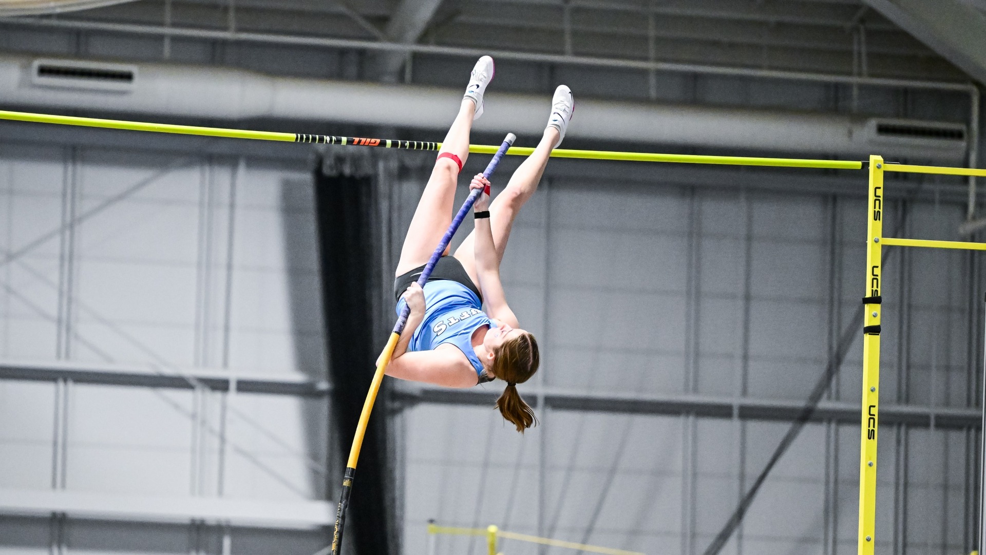 Emma Gall competes in the pole vault at Tufts' Gantcher Center.