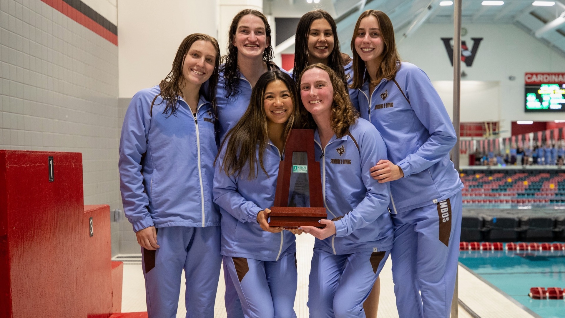 The Tufts women's swimming & diving seniors pose with the NESCAC runner-up placque.