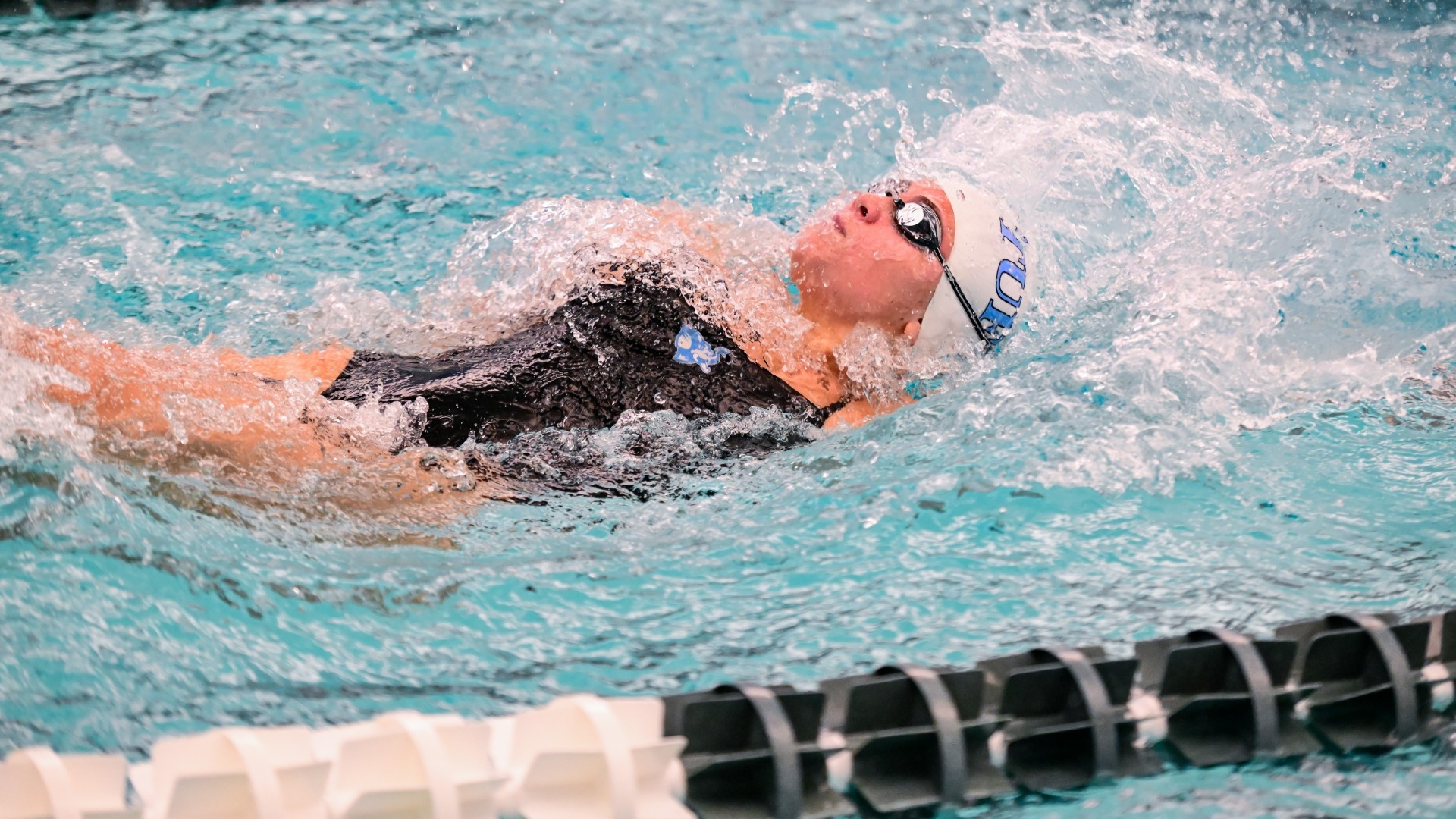 Anna Gjervold swims the backstroke in a meet at Brandeis.
