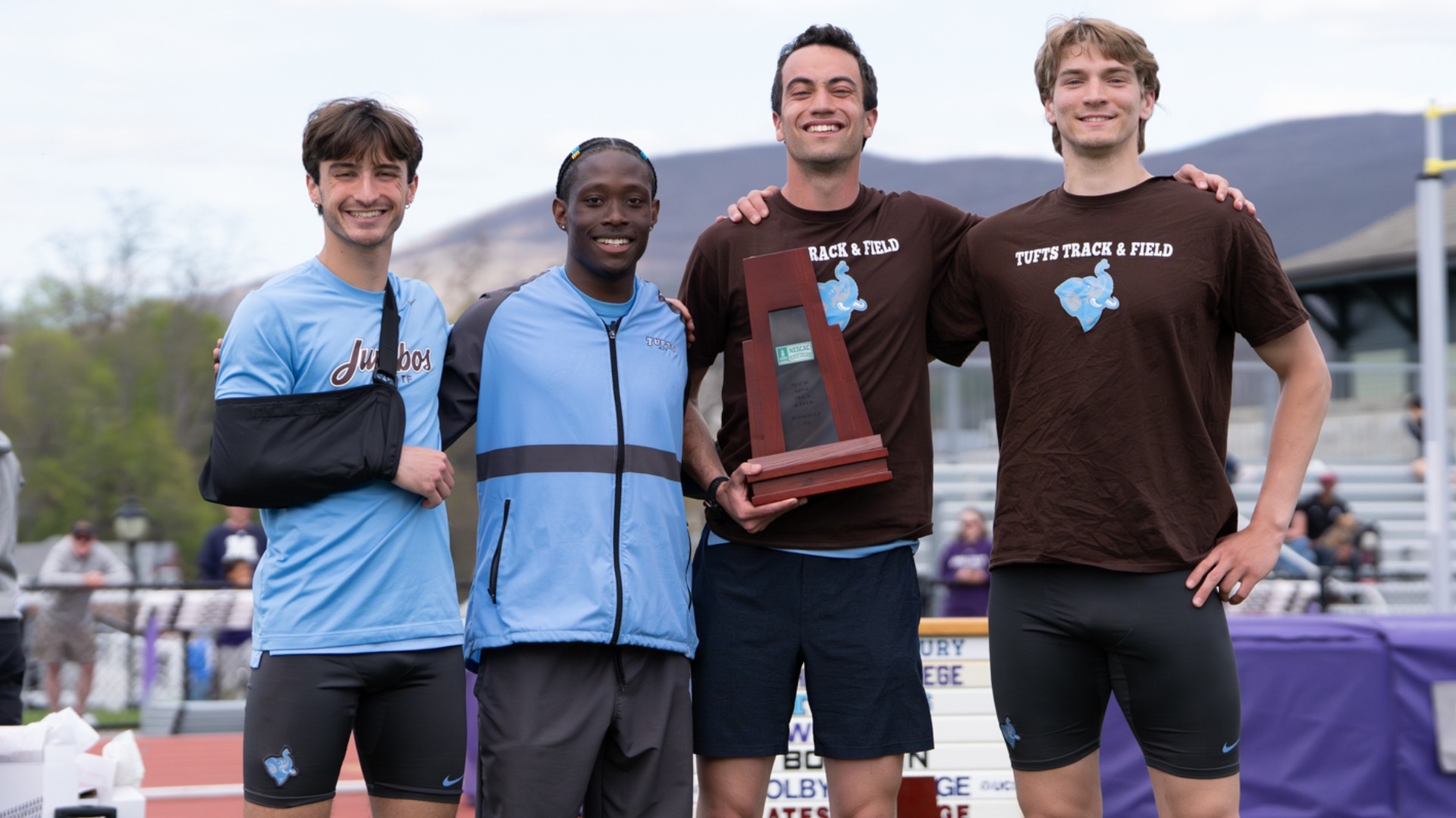 The Tufts men's track & field captains with the NESCAC runner-up trophy for 2026.