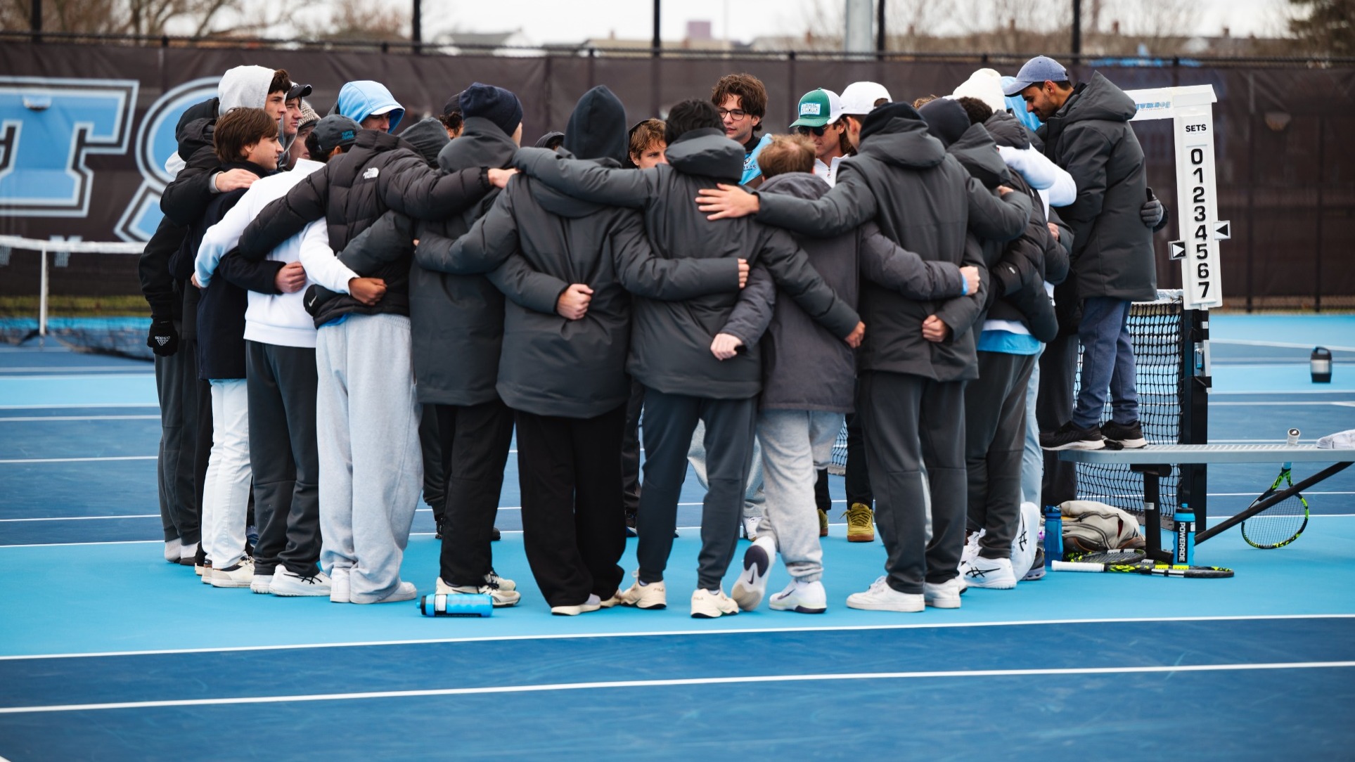 Tufts Men's Tennis Huddles Against Bowdoin College.