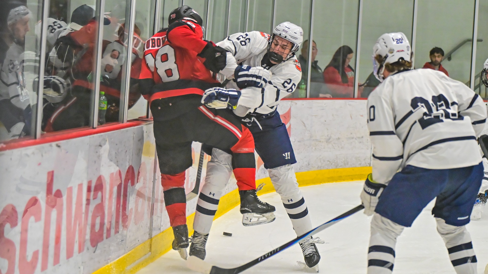 Isaac Flatley checks the Minot State skater into the boards