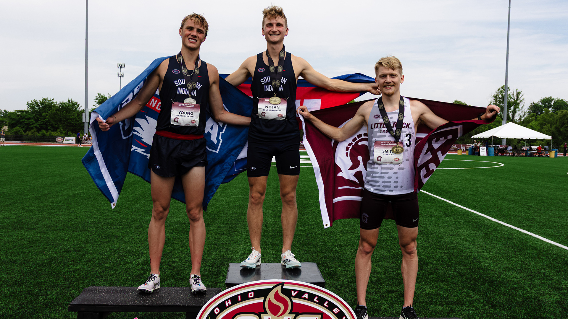 Alex Nolan (middle) and Kraedyn Young (left) on the podium after finishing first and second, respectively, in the 5,000 meters at the 2026 OVC Track & Field Championships May 16 in Little Rock, Arkansas.