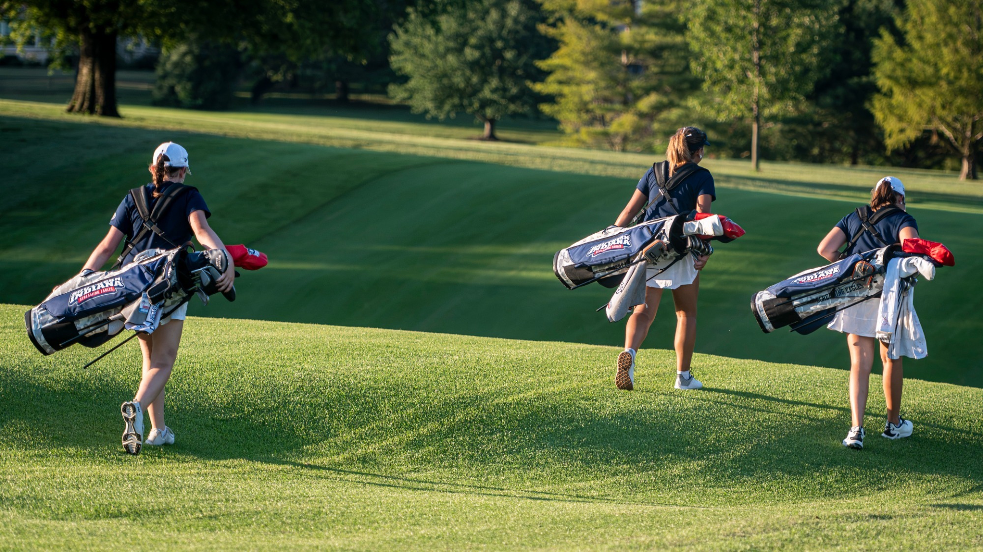 Photo from USI Women's Golf players walking with new bags during a practice round on August 27, 2026.