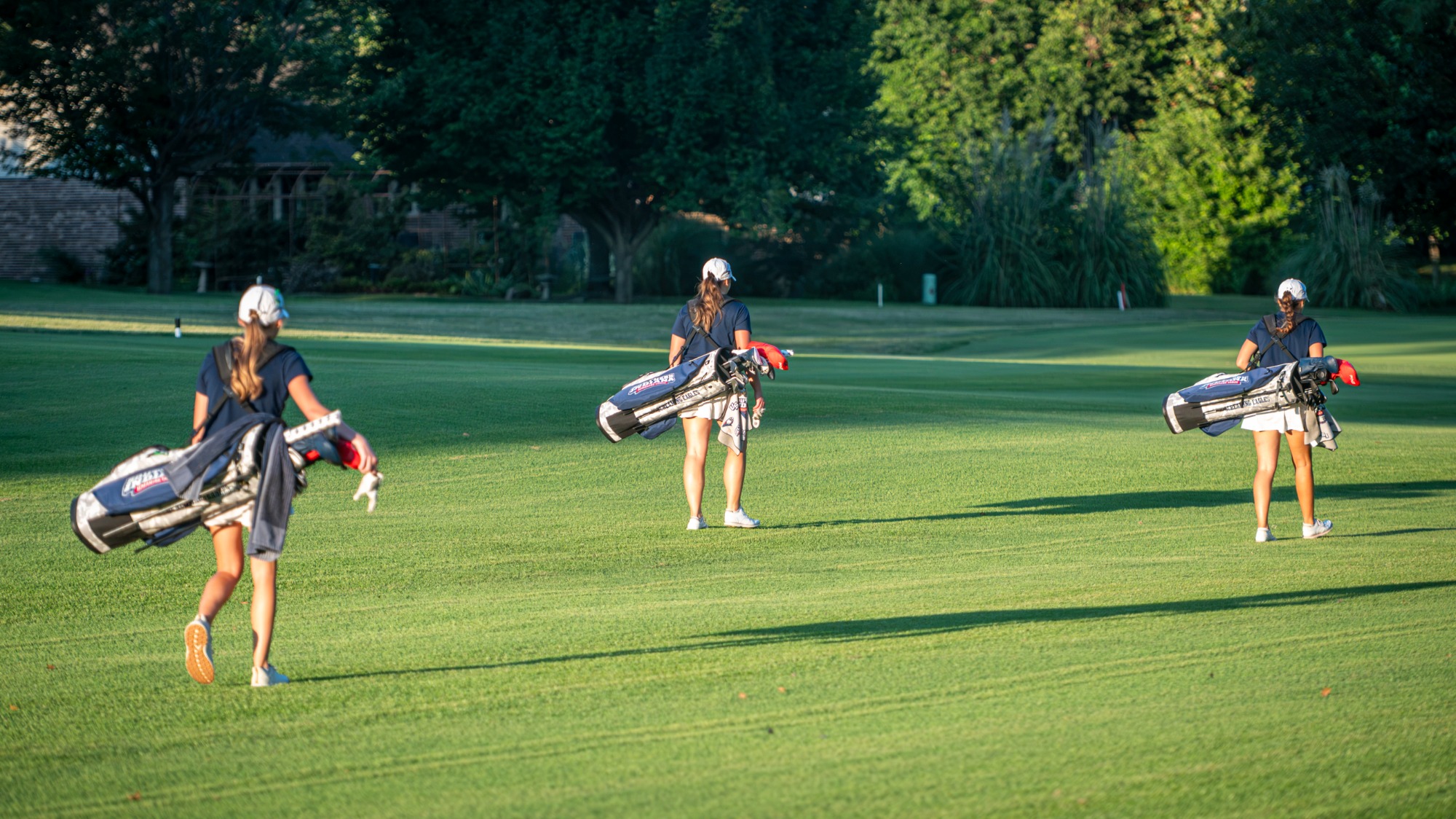 USI Women's Golf players walking with new bags during a practice round on August 27, 2026.