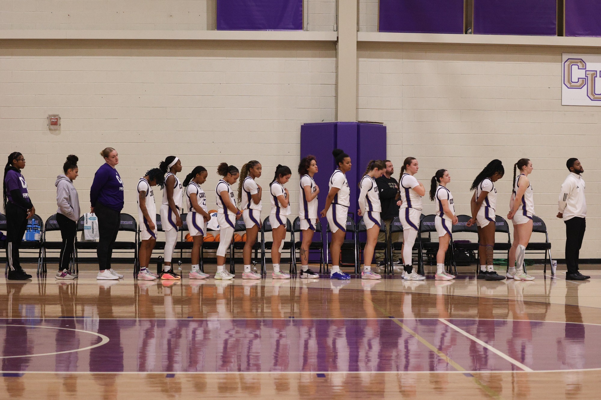 The women's basketball team stands for the national anthem