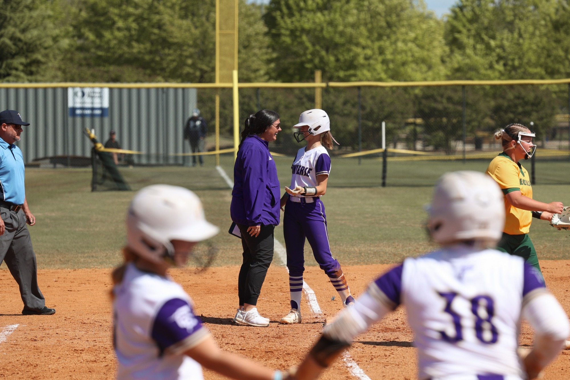 Head coach Jackie Huff celebrates with Aubree Leonard at third base