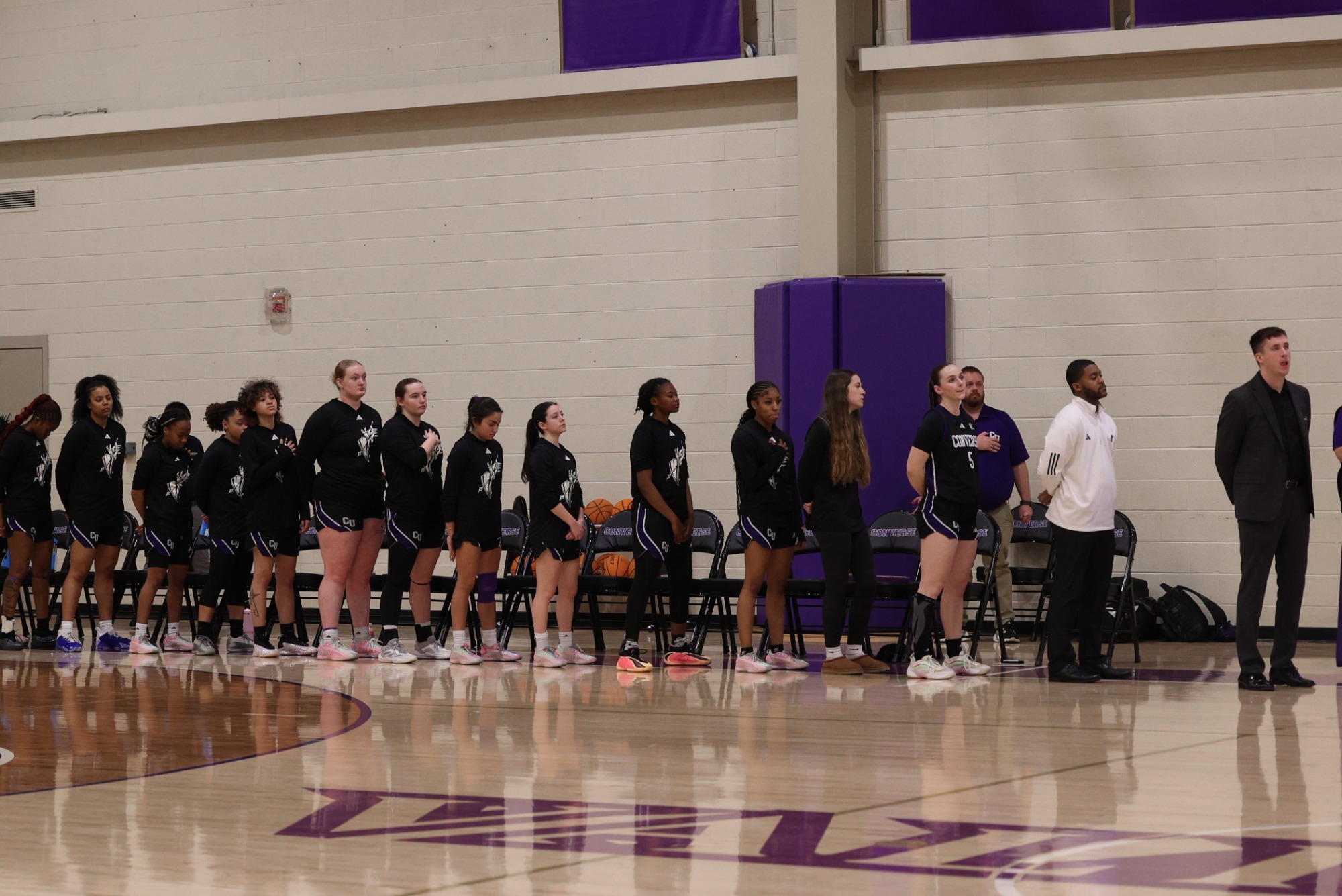 The Converse women's basketball team stands for the national anthem